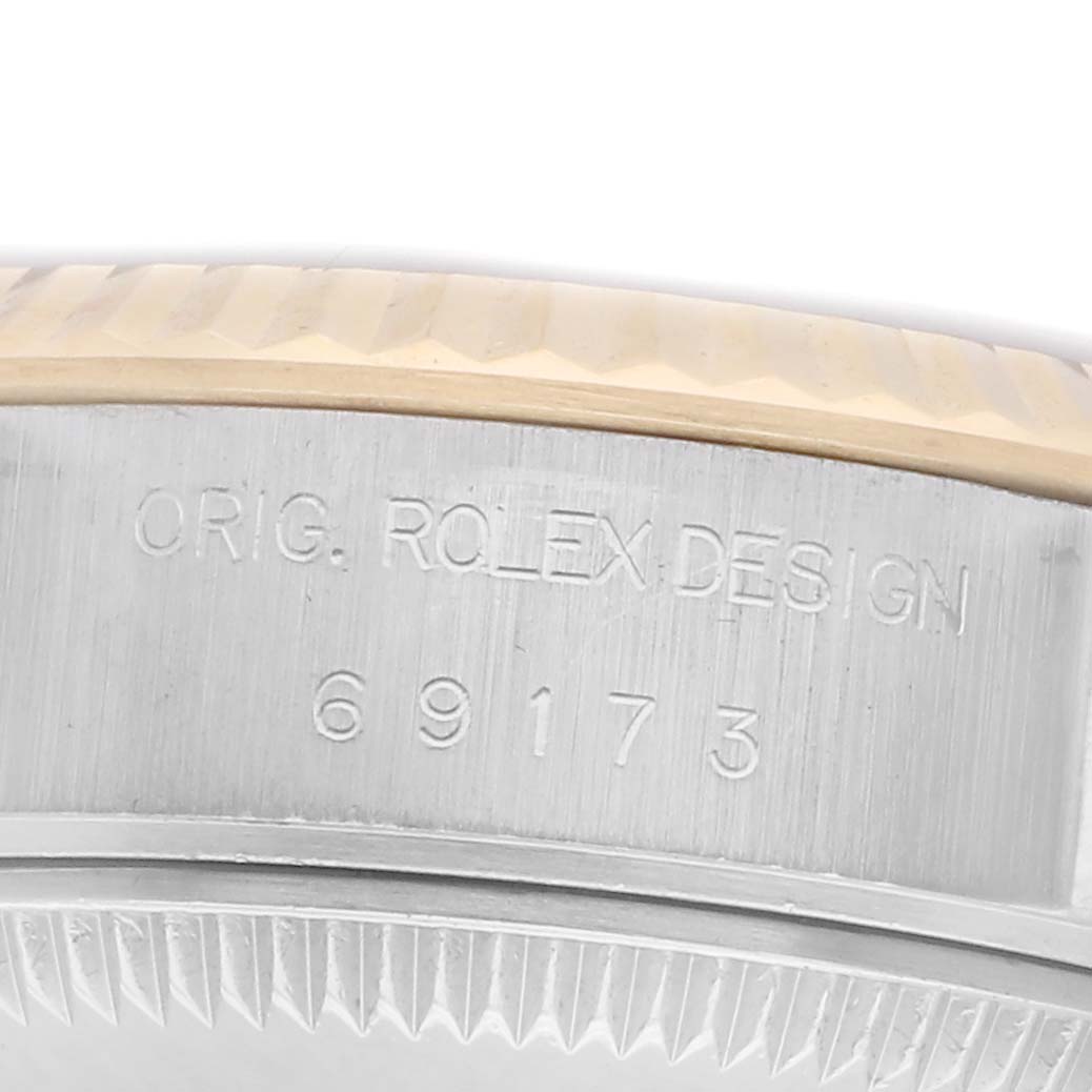 The image shows a close-up of the case side of a Rolex Datejust with model number 69173, highlighting the engravings and part of the fluted bezel.