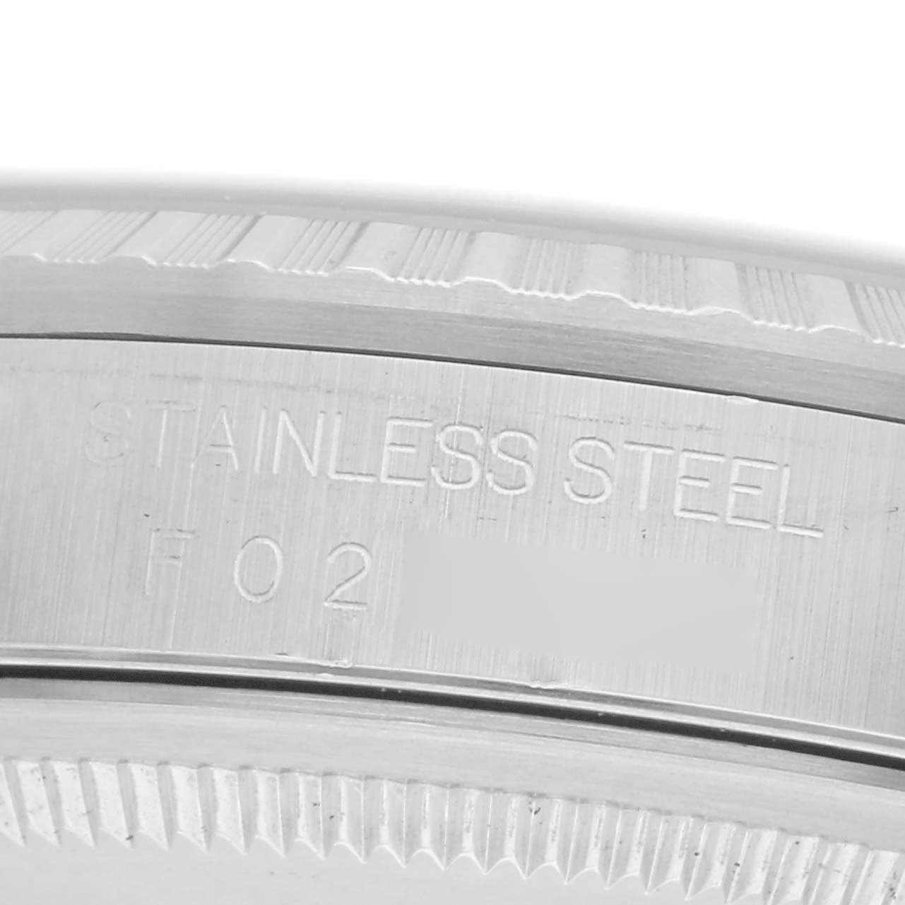 The image shows a close-up of the stainless steel rim of a Rolex Datejust model 16220, with visible engraving details.