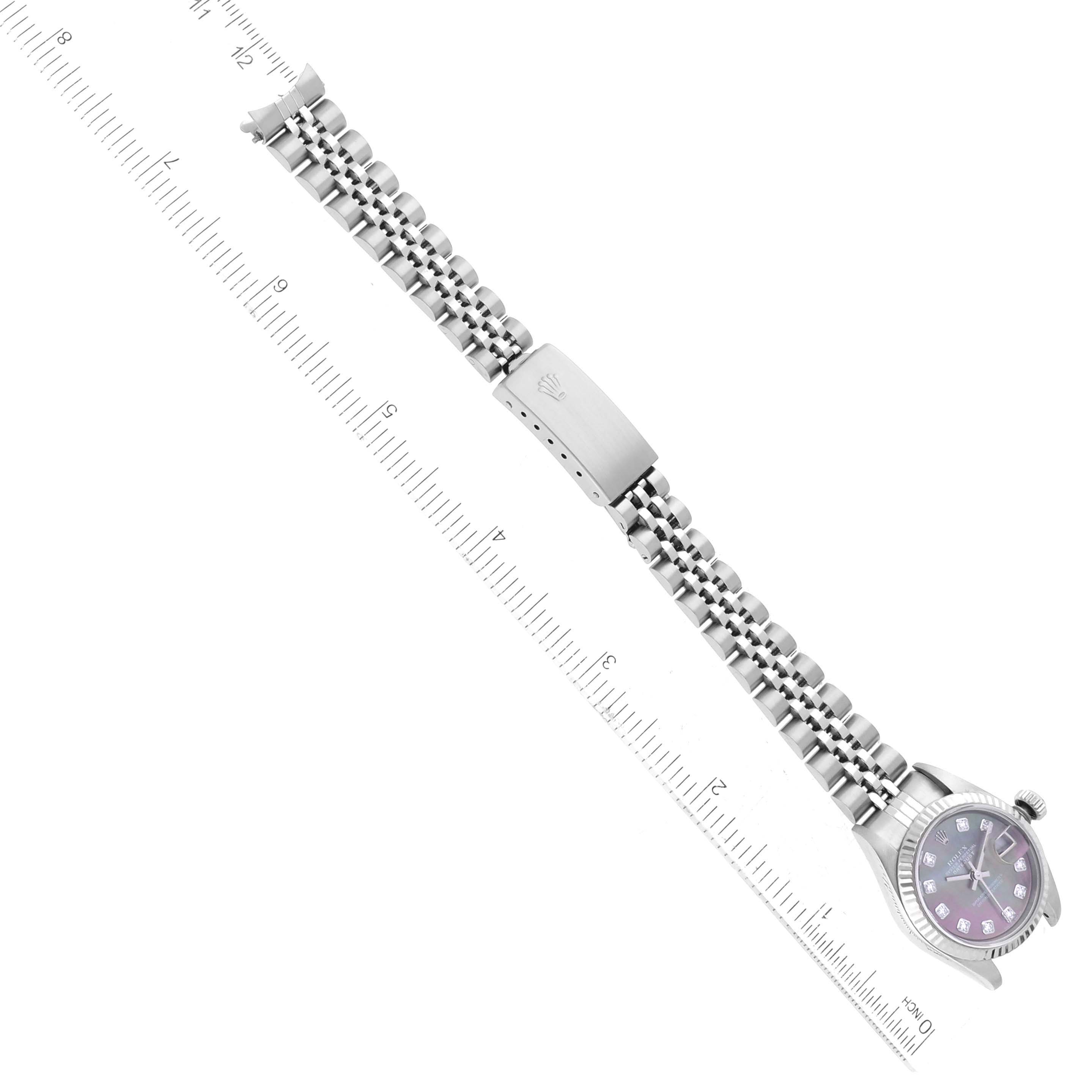 The Rolex Datejust 79174 Women
s Stainless Steel Mother of Pearl Dial 79174 Women
s Stainless Steel Mother of Pearl Dial watch is shown in an angled top-down view with the full bracelet and clasp visible alongside a measuring ruler.