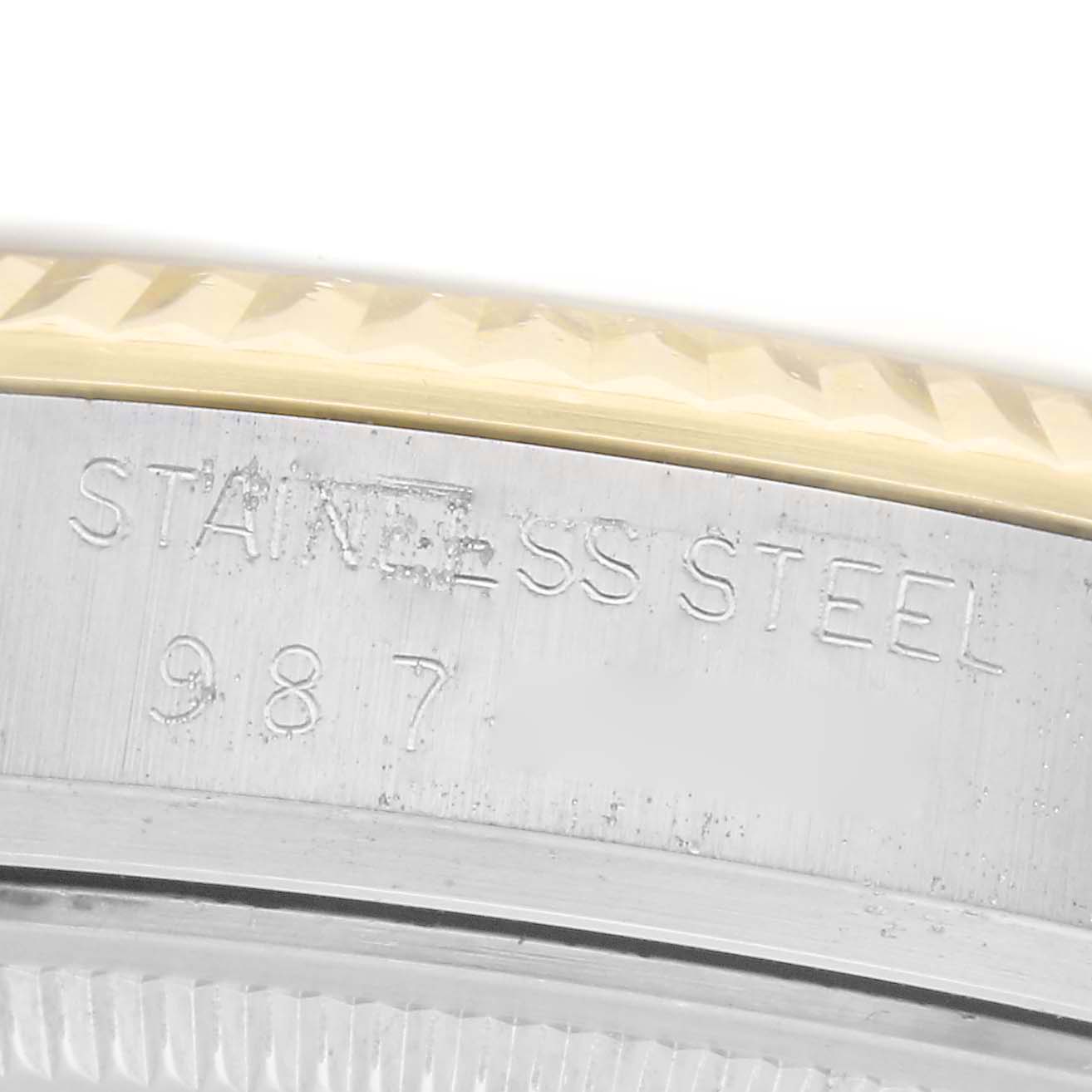 The image shows a close-up of the case edge of a Rolex Datejust, model 16013, highlighting the stainless steel marking and part of the fluted bezel.