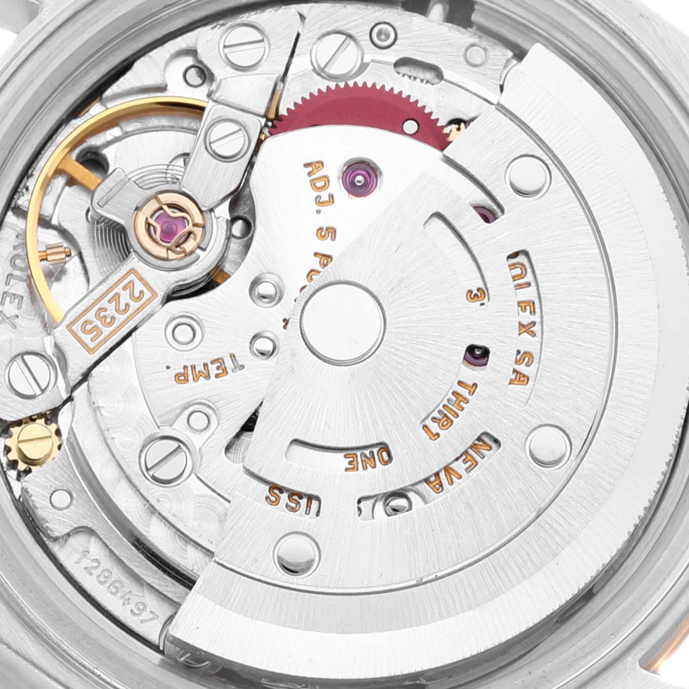 The image shows an up-close view of the Rolex Datejust 79173 Women
s Steel and Gold (two tone) Champagne Dial 79173 Women
s Steel and Gold (two tone) Champagne Dial watch movement, highlighting mechanisms such as gears and inscriptions.