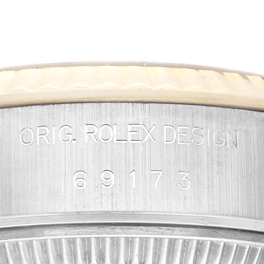 Close-up of the side of the case of a Rolex Datejust 69173 Women's Steel and Gold (two tone) Champagne Dial 69173 Women's Steel and Gold (two tone) Champagne Dial model, showing the engraved serial number "69173" and the text "ORIG. ROLEX DESIGN."