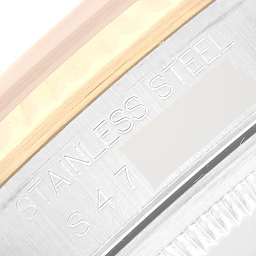 This close-up of a Rolex Datejust 16233 Men's Steel and Gold (two tone) Beige Dial 16233 Men's Steel and Gold (two tone) Beige Dial watch shows the edge of the watch case, indicating "Stainless Steel" with a partial view of the bezel.