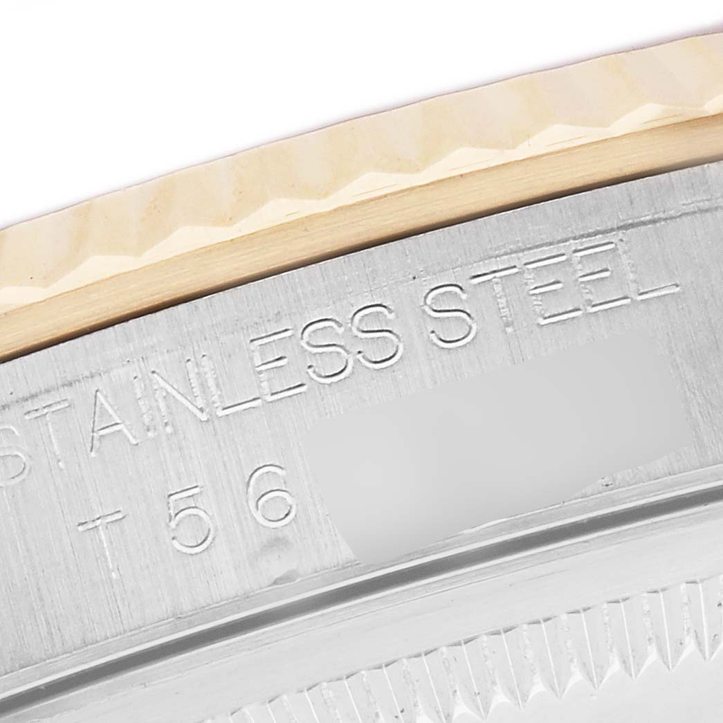 The image shows a close-up of the Rolex Datejust model 16233, focusing on the stainless steel and gold fluted bezel with engraving details visible.