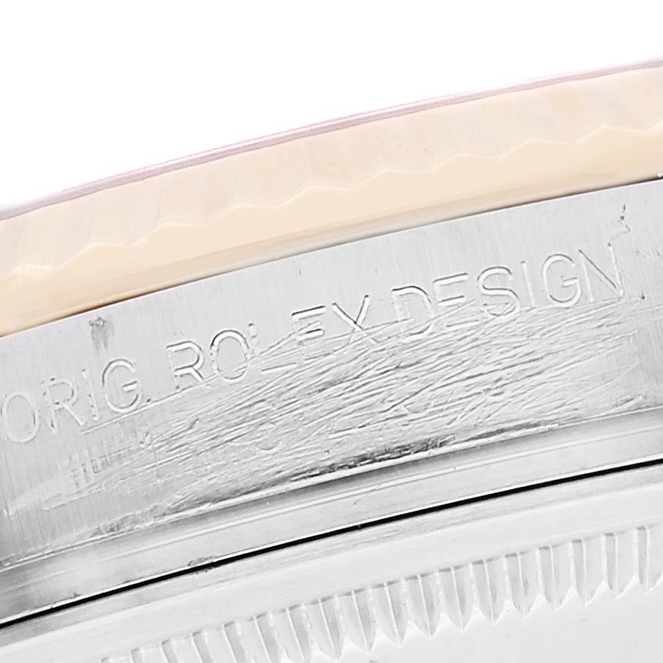The image shows a close-up of the side of a Rolex Datejust 116233 Men's Stainless Steel White Dial 116233 Men's Stainless Steel White Dial watch case with engraved text.