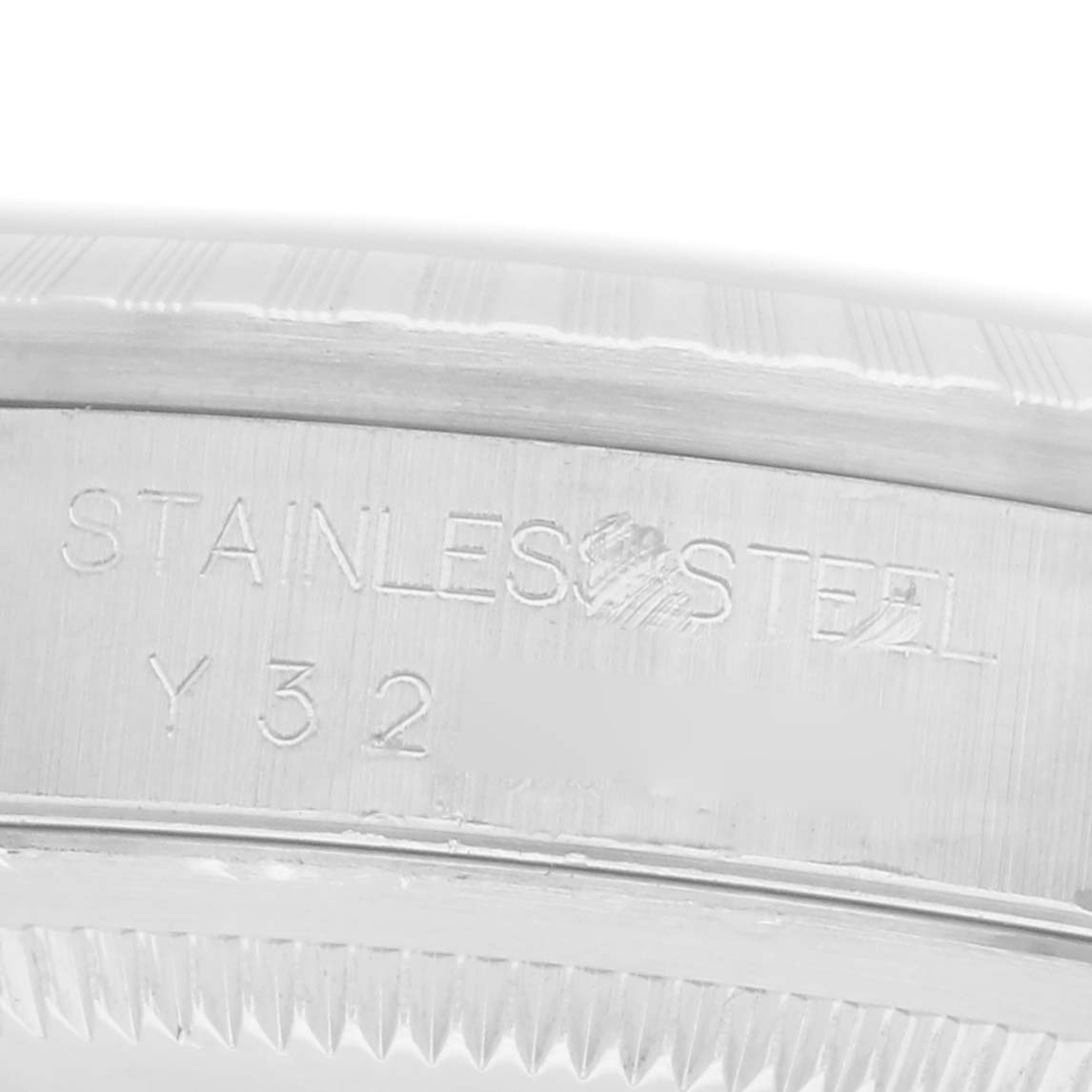 The image shows a close-up of the etched side of a Rolex Datejust men
s watch, model 16220, highlighting the "STAINLESS STEEL" engraving and part of the case edge.