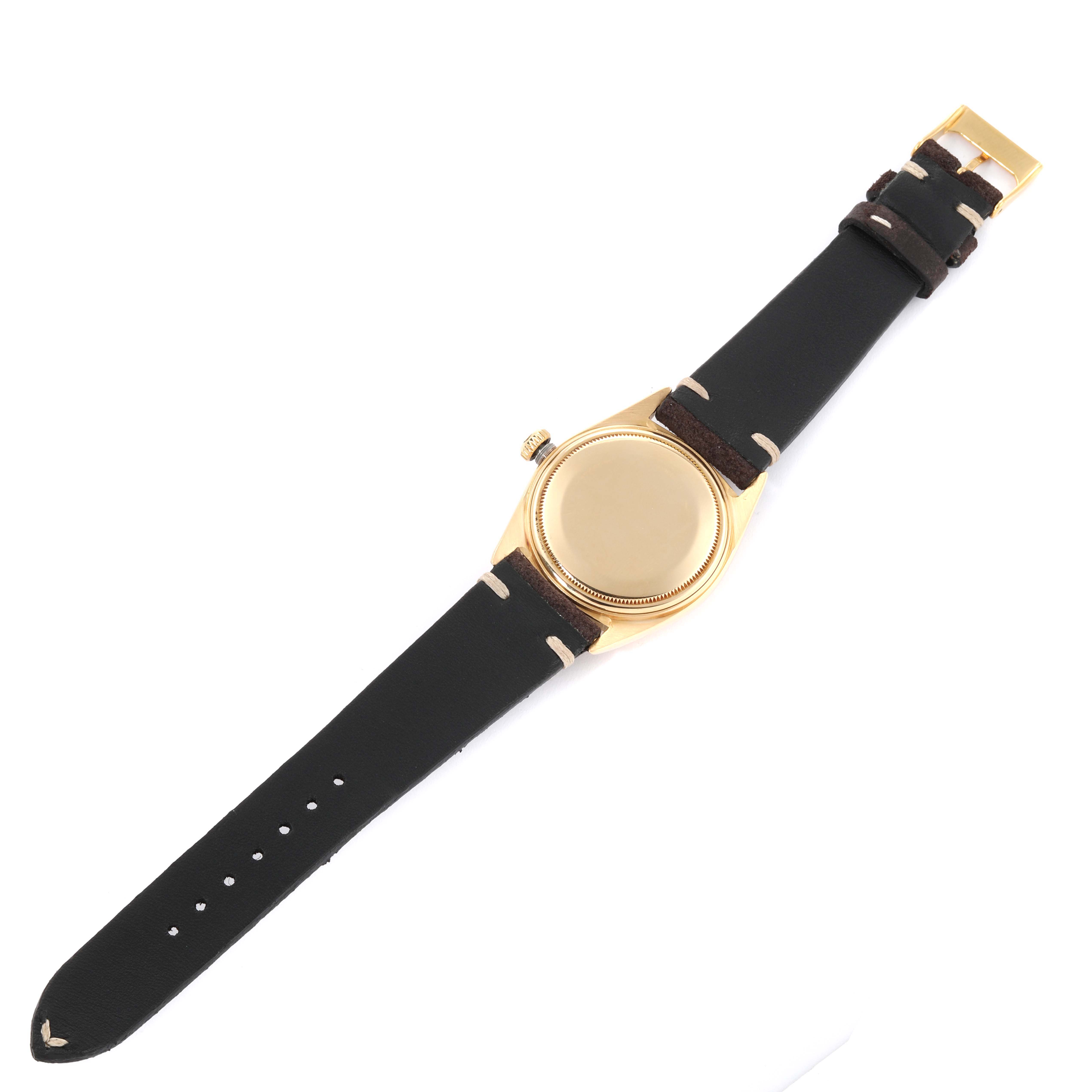 The image shows a top view of a Vintage Collection Rolex watch, displaying the case back, crown, and black leather straps.