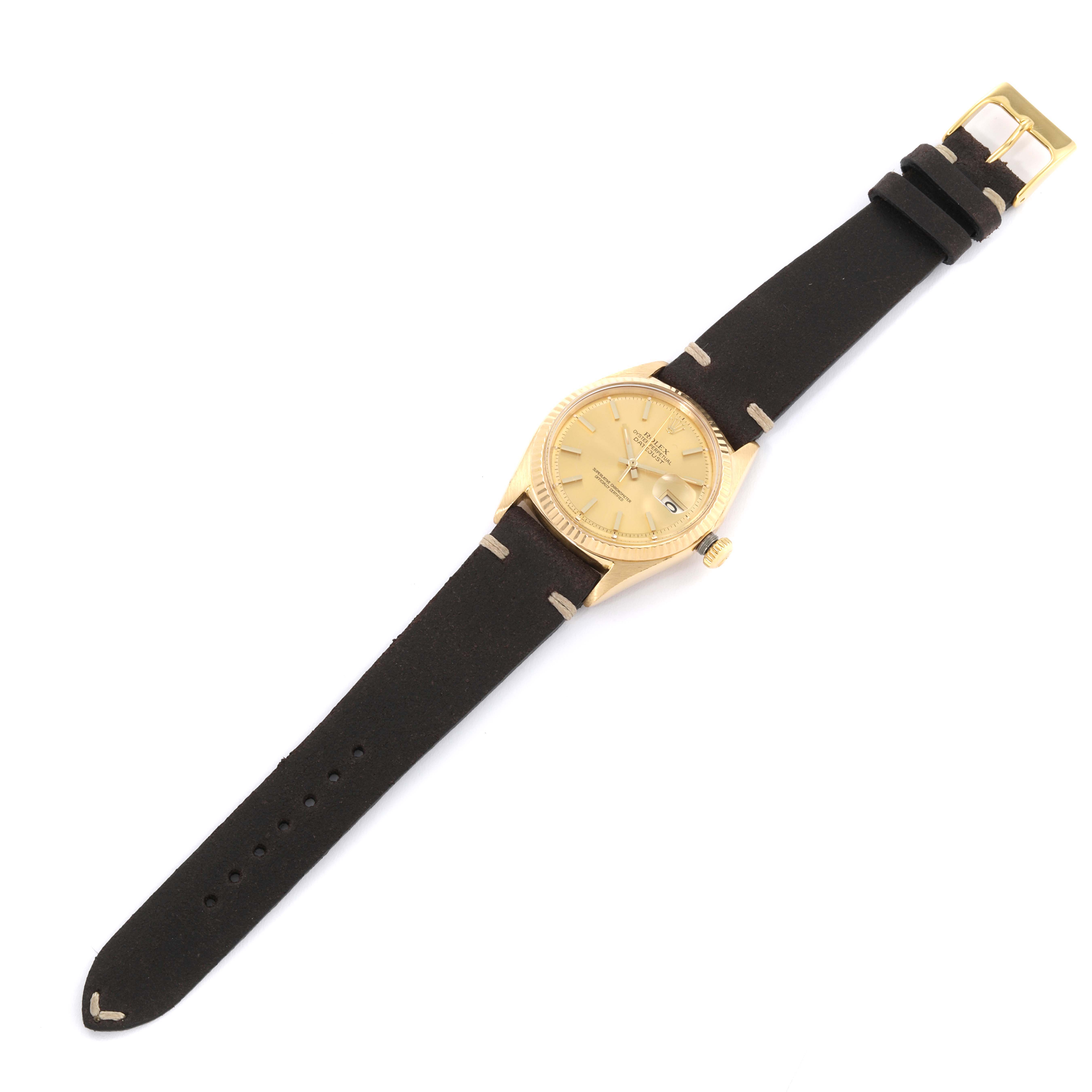 The Rolex Vintage Collection 1601 Men's Yellow Gold Champagne Dial 1601 Men's Yellow Gold Champagne Dial watch is shown from a top-down angle, displaying its gold case, dial, black leather strap, and buckle.