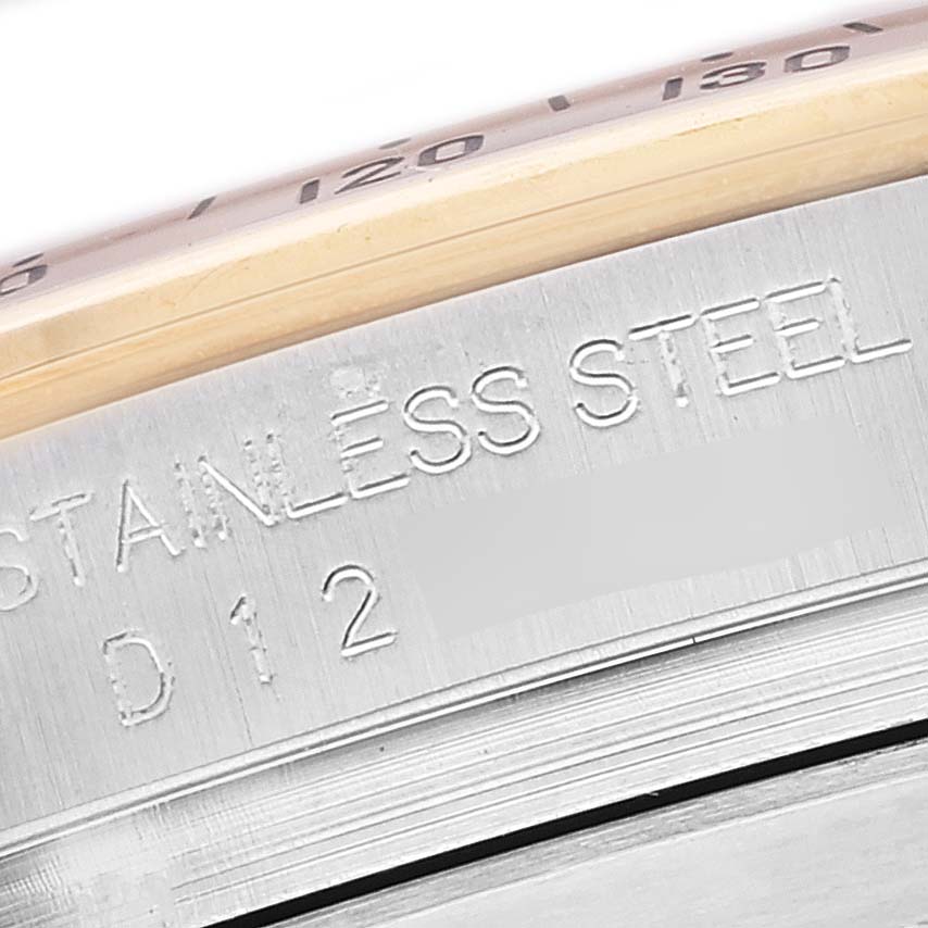 The image shows a close-up of the side of the stainless steel case of a Rolex Daytona 116523 Men
s Steel and Gold (two tone) Black Dial 116523 Men
s Steel and Gold (two tone) Black Dial watch, highlighting the engraved text.