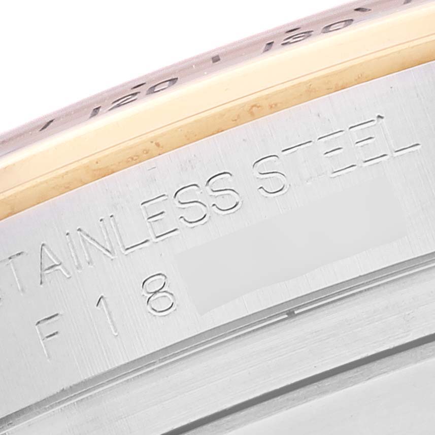 This close-up shows the side of the stainless steel case of a Rolex Daytona 116523 Men's Steel and Gold (two tone) Black Dial 116523 Men's Steel and Gold (two tone) Black Dial watch, highlighting the engraved text.