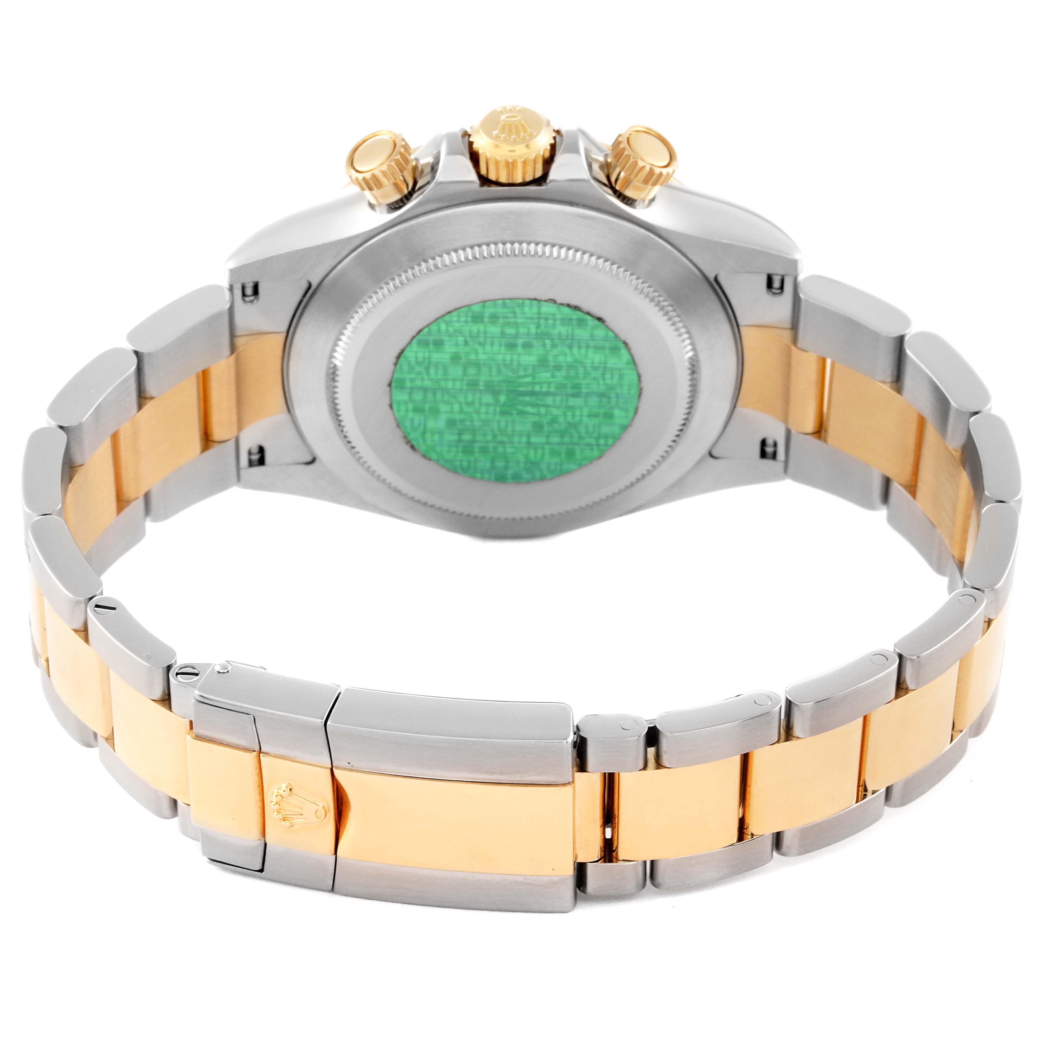 This image shows the back and bracelet of a Rolex Daytona 116523 Men's Steel and Gold (two tone) Black Dial 116523 Men's Steel and Gold (two tone) Black Dial watch, highlighting the gold and silver links and the green sticker on the back.
