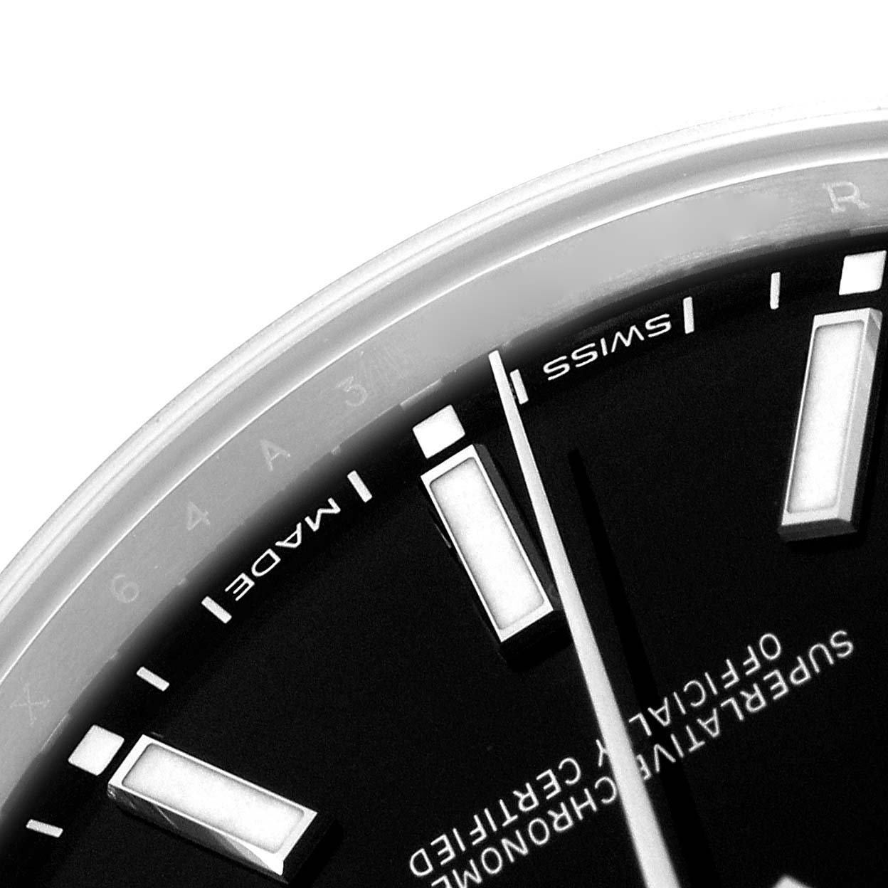 The image shows a close-up of a Rolex Oyster Perpetual model 114300 watch face, highlighting the dial, markers, and part of the bezel.