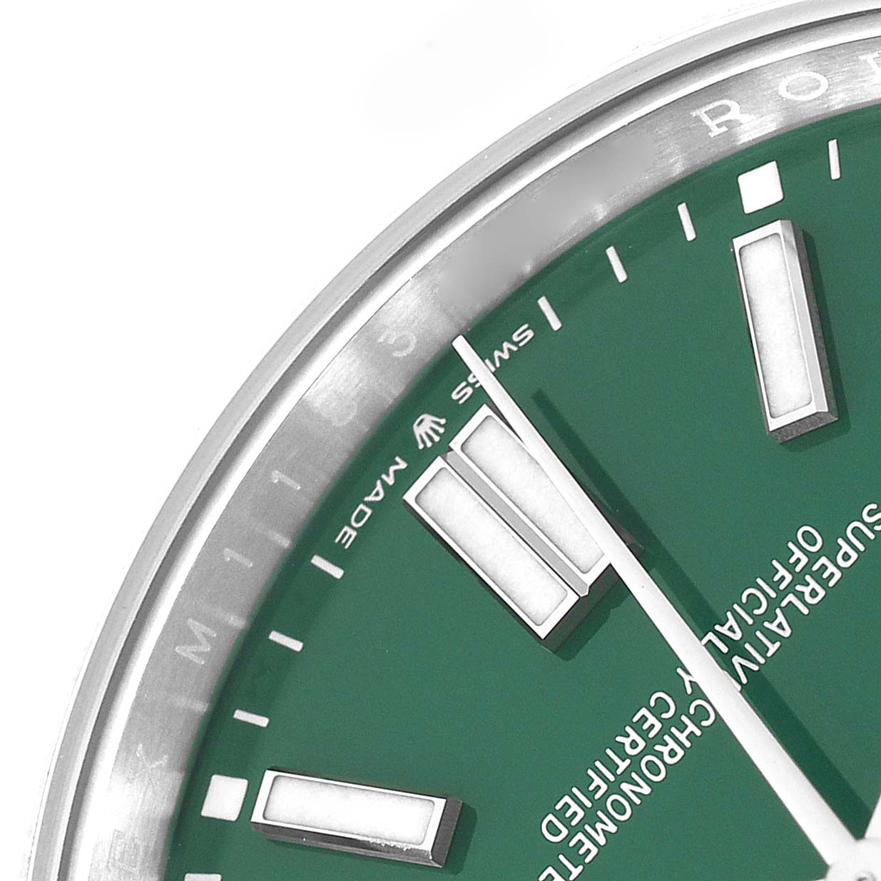 The image shows a close-up of the dial and bezel of a Rolex Oyster Perpetual 124300 watch, highlighting the green dial and indices.