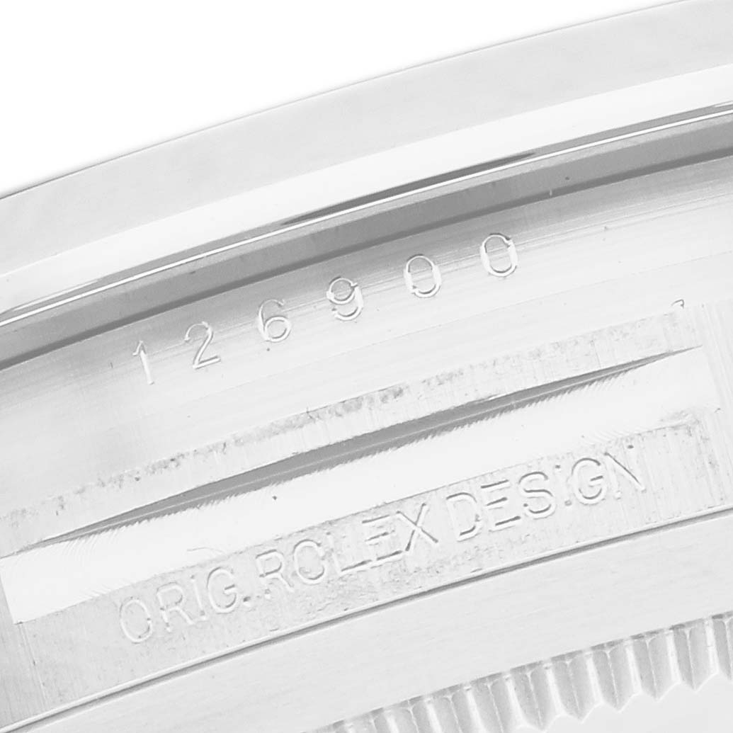 The image shows a close-up of the case back of a Rolex Air-King model 126900, highlighting the engraved model number and design details.