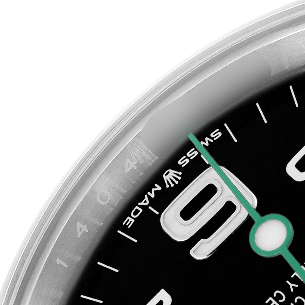 The image shows a close-up of the dial and bezel edge of a Rolex Air-King model 126900, highlighting the numerals and sweep second hand.
