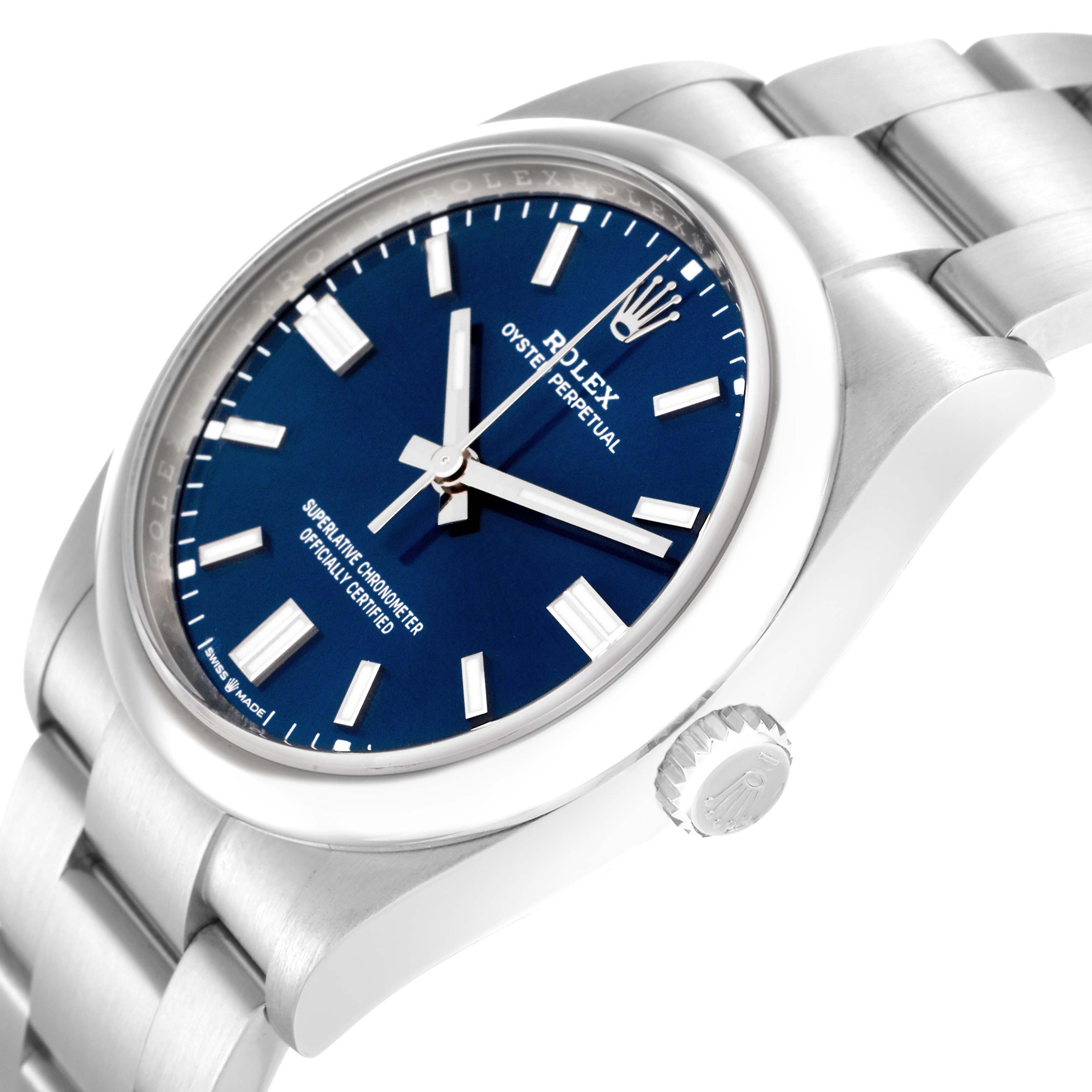 The image shows a side angle of the Rolex Oyster Perpetual 126000 men's watch, highlighting the blue dial, bezel, crown, and part of the bracelet.