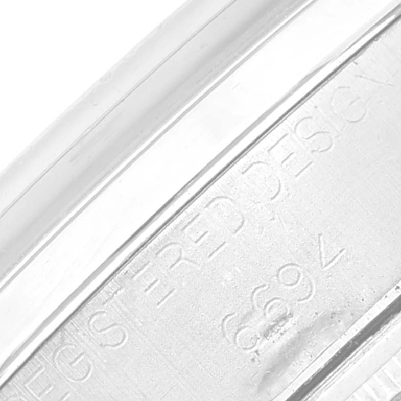 This is a close-up image of the side of a Rolex Vintage Collection 6694 Men's Stainless Steel Silver Dial 6694 Men's Stainless Steel Silver Dial watch with visible engraving.