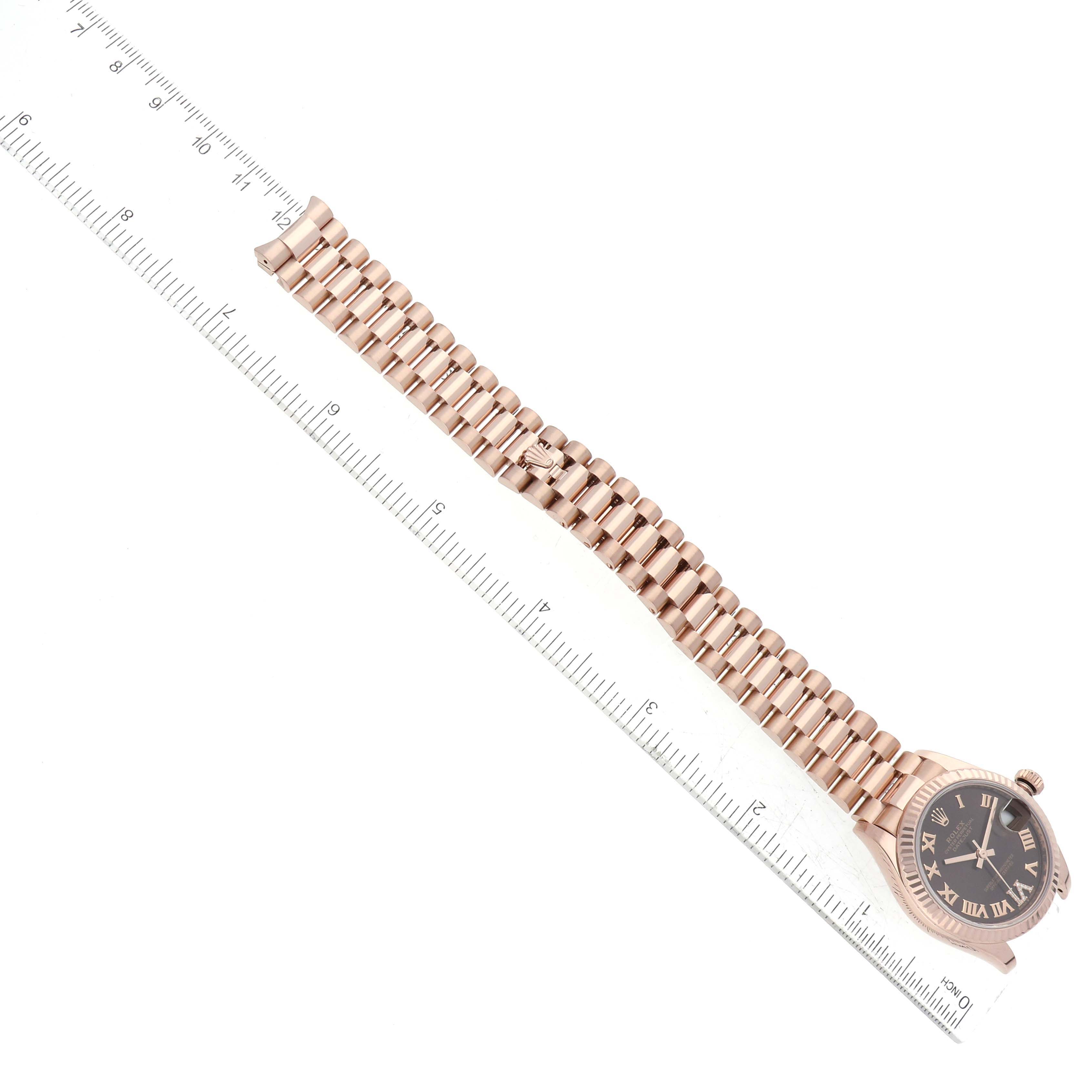 The image shows a top-down view of a Rolex President 278275 Women's Rose Gold Brown Dial 278275 Women's Rose Gold Brown Dial model watch, including its bracelet and face, next to a ruler for size reference.
