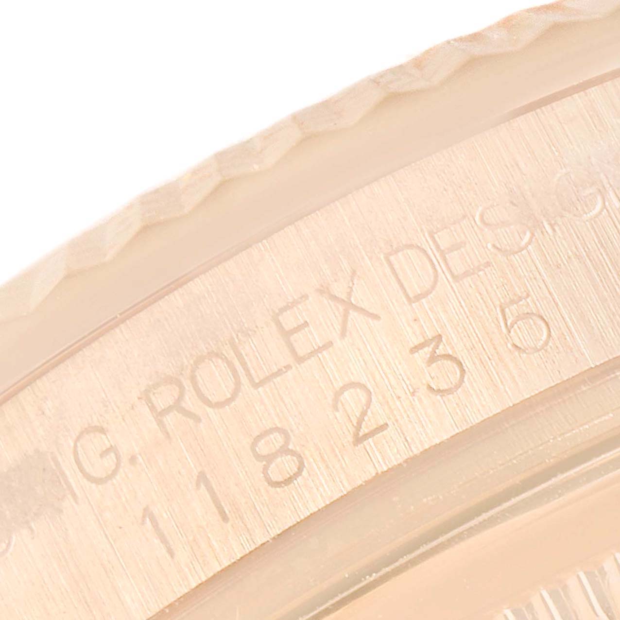 The image shows a close-up of the side engraving and fluted bezel of the Rolex President 118235 Men's Rose Gold Pink Dial 118235 Men's Rose Gold Pink Dial watch model.