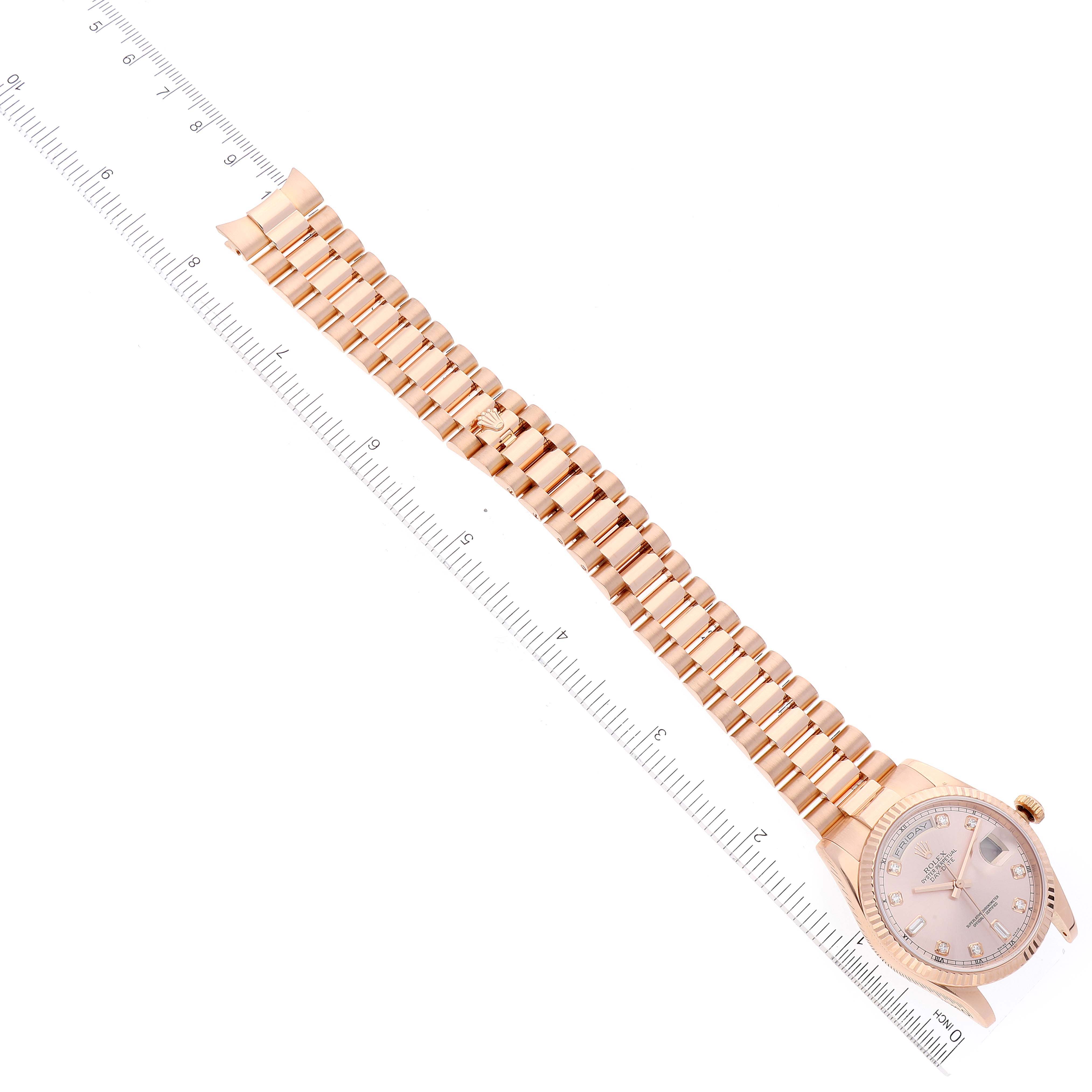 The image shows an overhead view of a Rolex President 118235 Men's Rose Gold Pink Dial 118235 Men's Rose Gold Pink Dial model watch, including its watch face and full bracelet next to a ruler.