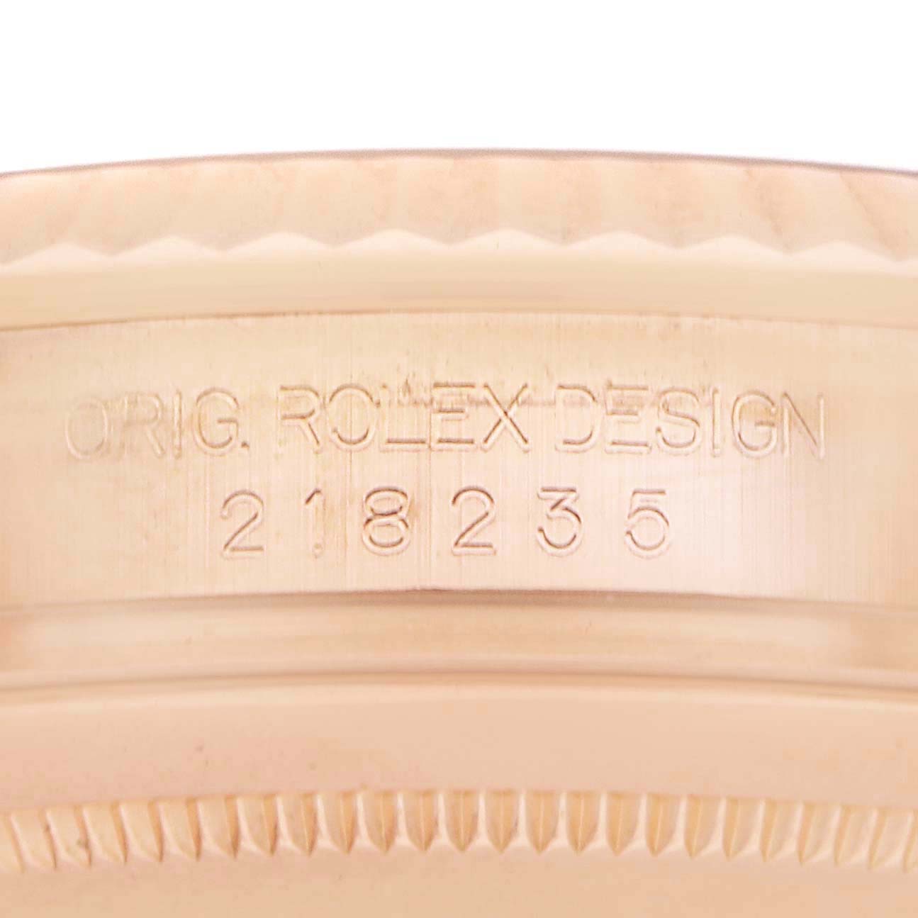 The image shows a close-up of the engraved case edge on a Rolex President model, model number 218235, displaying "ORIG. ROLEX DESIGN 218235."