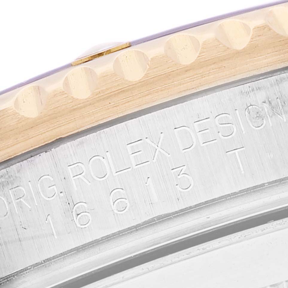 The image shows a close-up of the edge and bezel of a Rolex Submariner 16613 Men
s Steel and Gold (two tone) Blue Dial 16613 Men
s Steel and Gold (two tone) Blue Dial, focusing on the engraving and detailing.