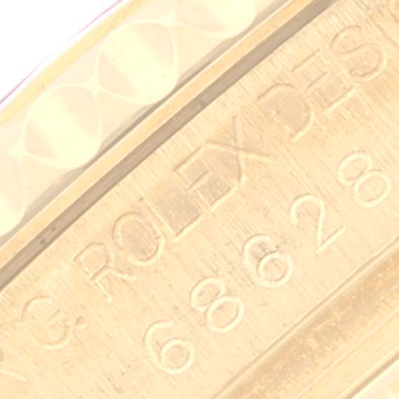 This close-up image shows the engraved serial number and part of the bezel of the Rolex Yacht-Master 68628 Men's Yellow Gold Blue Dial 68628 Men's Yellow Gold Blue Dial watch.