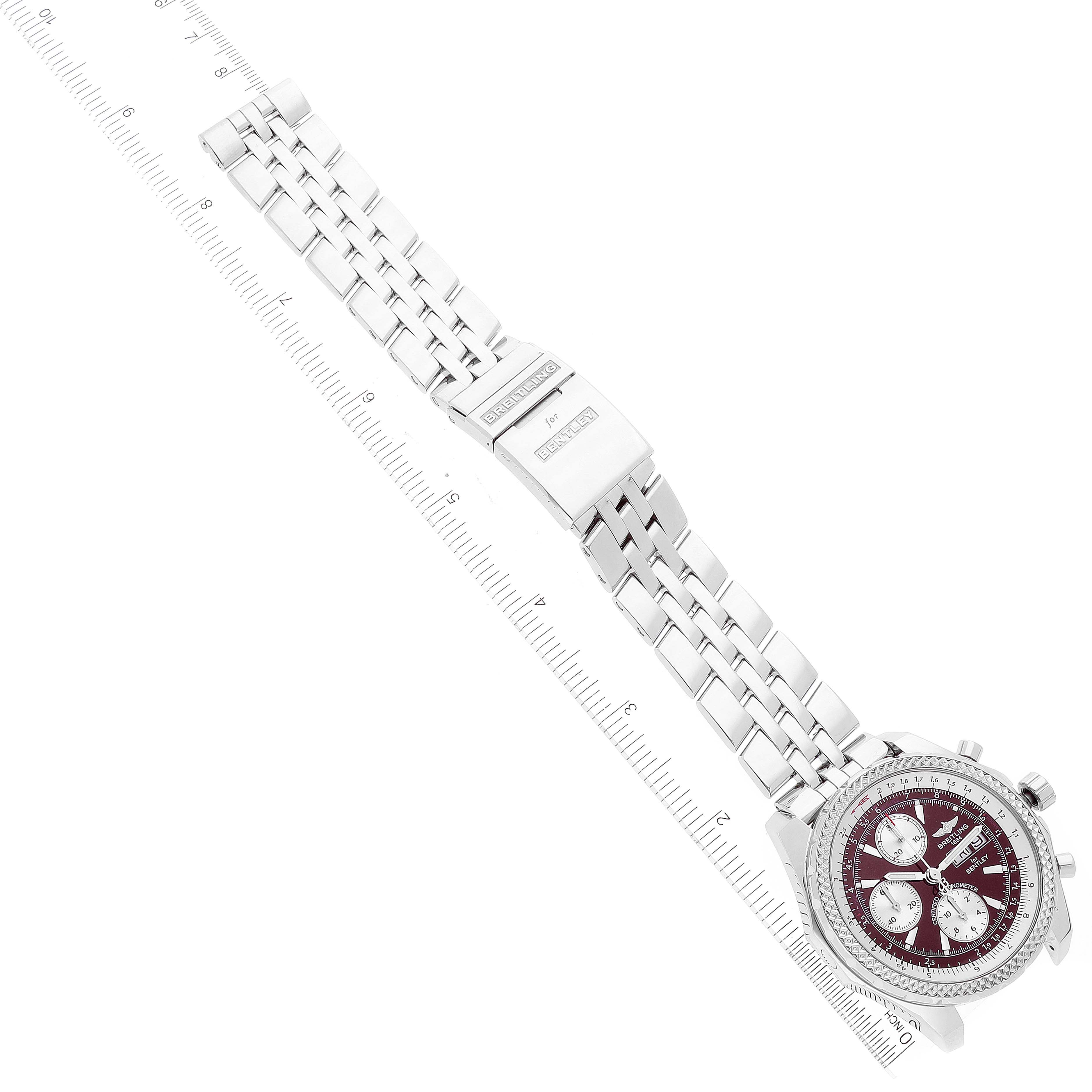 The image displays a top-down view of the Breitling Bentley A13362 Men's Stainless Steel Burgundy Dial A13362 Men's Stainless Steel Burgundy Dial watch, highlighting its face and metal bracelet laid against a ruler.