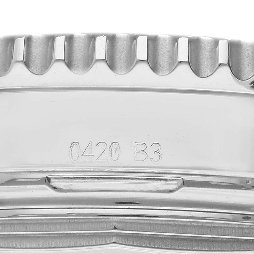 This close-up image shows the side of a Breitling Navitimer AB0121 Men's Stainless Steel Grey Dial AB0121 Men's Stainless Steel Grey Dial watch, focusing on its engraved serial number and ridged bezel.