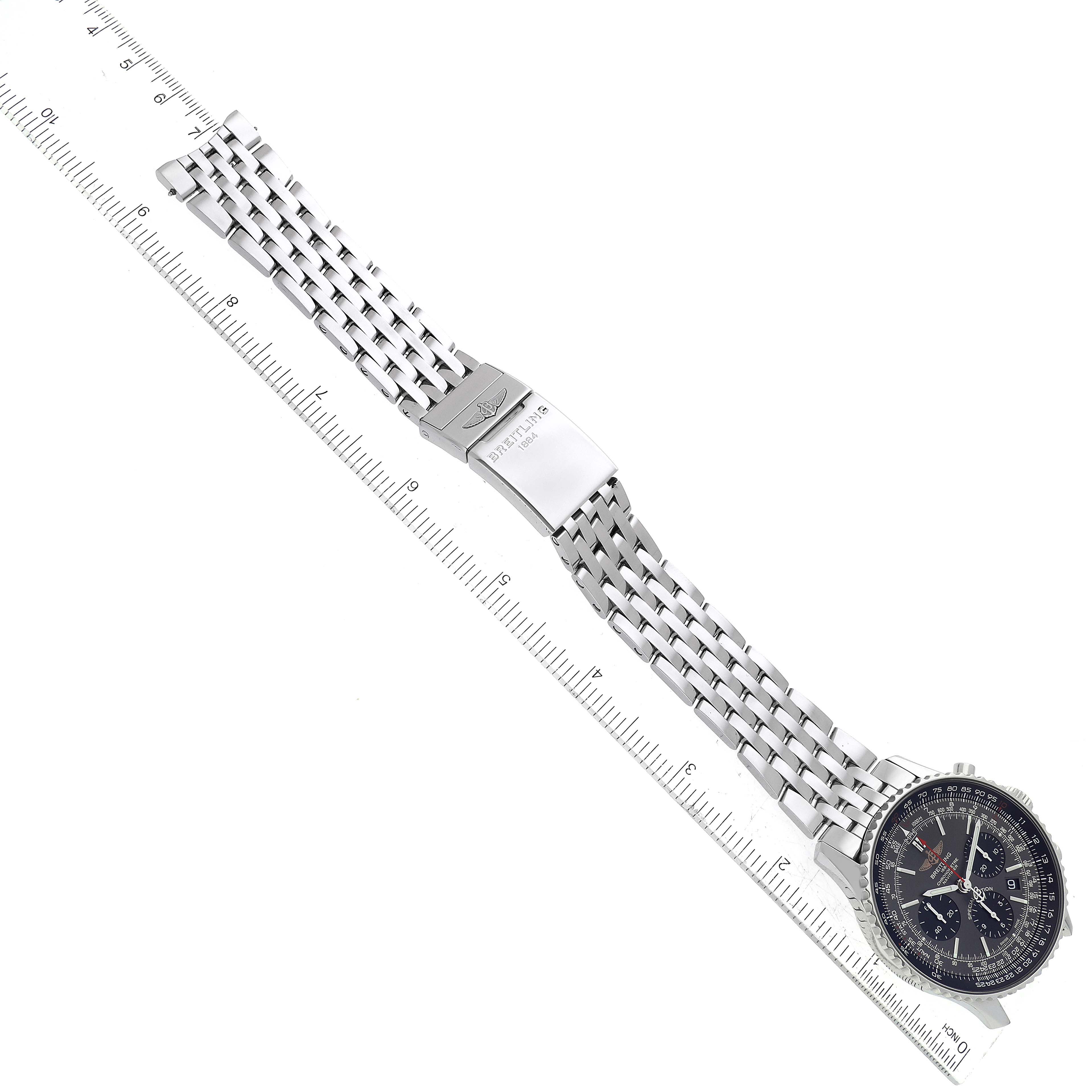 The image shows a Breitling Navitimer AB0121 Men's Stainless Steel Grey Dial AB0121 Men's Stainless Steel Grey Dial watch laid flat alongside a ruler for scale, highlighting the dial, bezel, and metal strap with clasp.