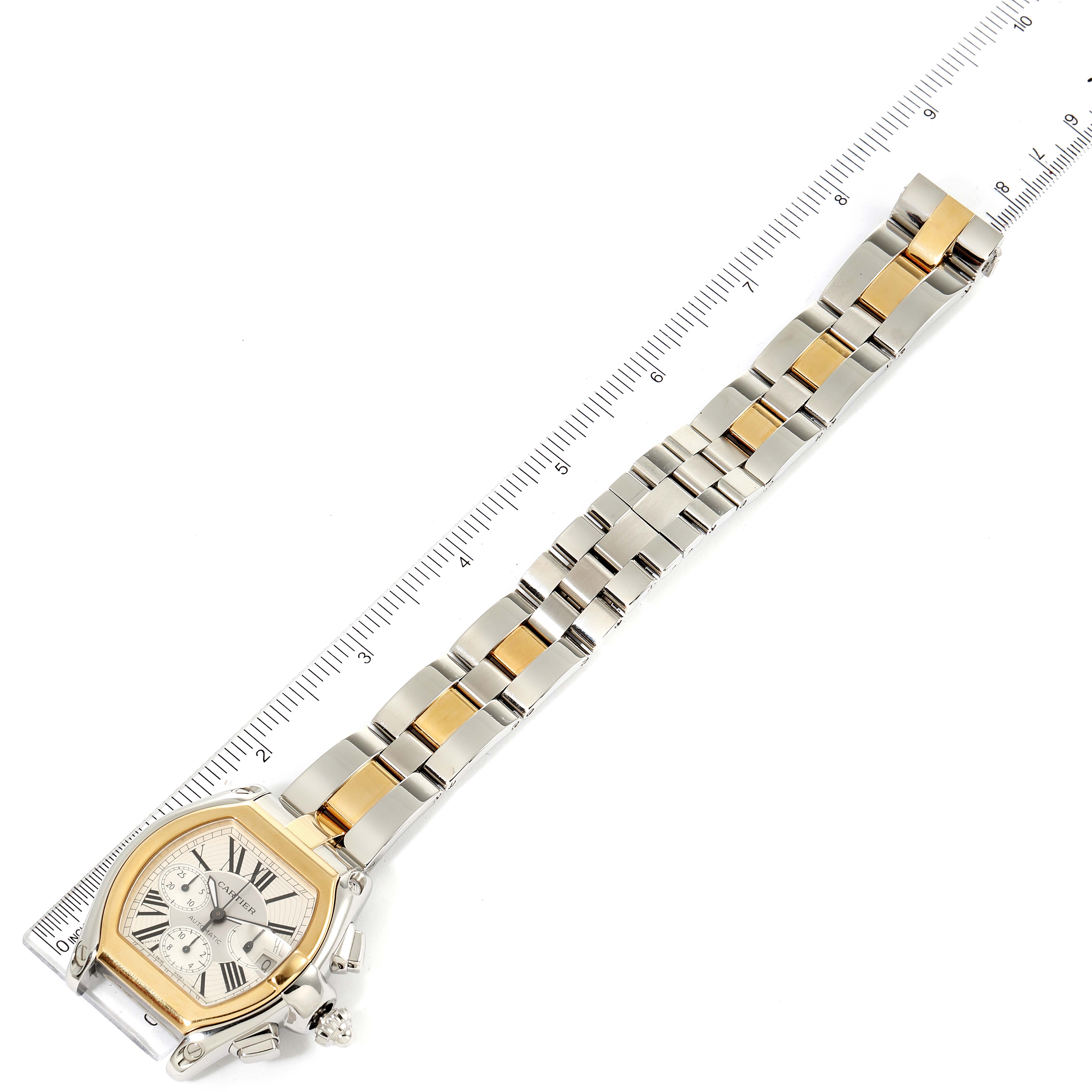 The Cartier Roadster W62027Z1 Men's Steel and Gold (two tone) Silver Dial W62027Z1 Men's Steel and Gold (two tone) Silver Dial watch is shown from an overhead angle, displaying the face and full metal bracelet alongside a ruler for scale.