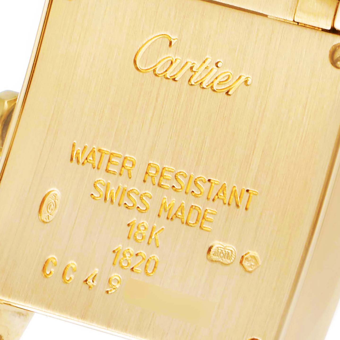 This image shows the engraved back of a Cartier Tank Française watch, highlighting details like "Water Resistant" and "18K".