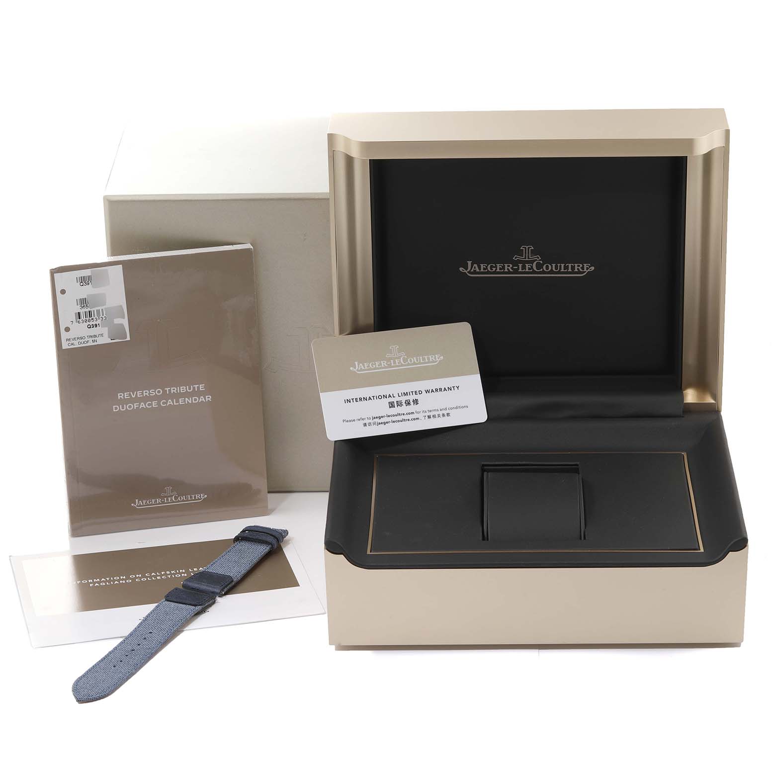The image shows the packaging, a strap, warranty card, and manuals for the Jaeger-LeCoultre Reverso model, displayed from the front.