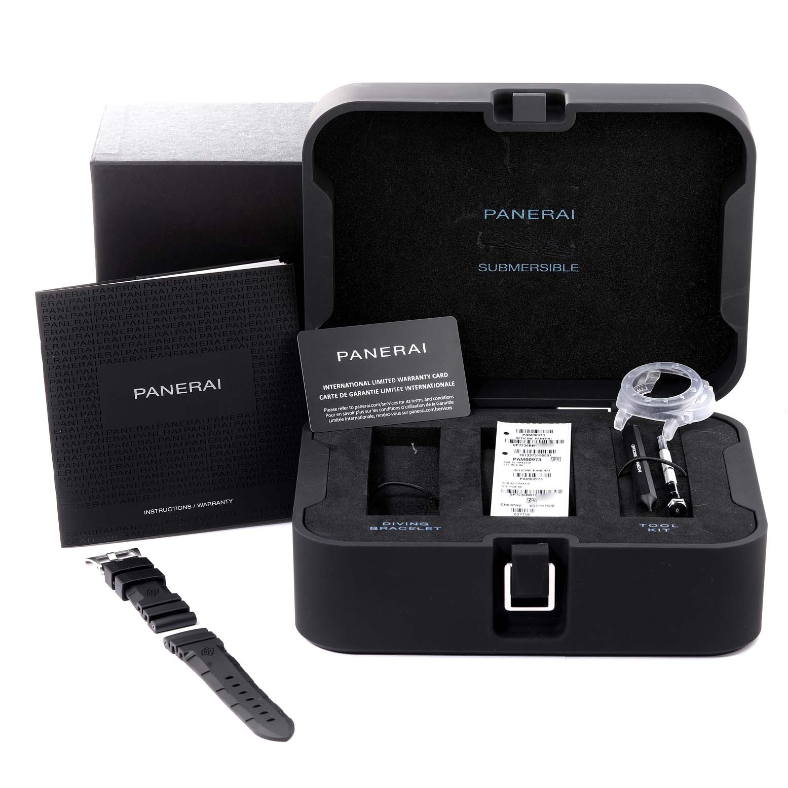 The image shows the open box of a Panerai Submersible PAM00973 Men's Stainless Steel Black Dial PAM00973 Men's Stainless Steel Black Dial watch, displaying a strap, instructions, a warranty card, and tools.