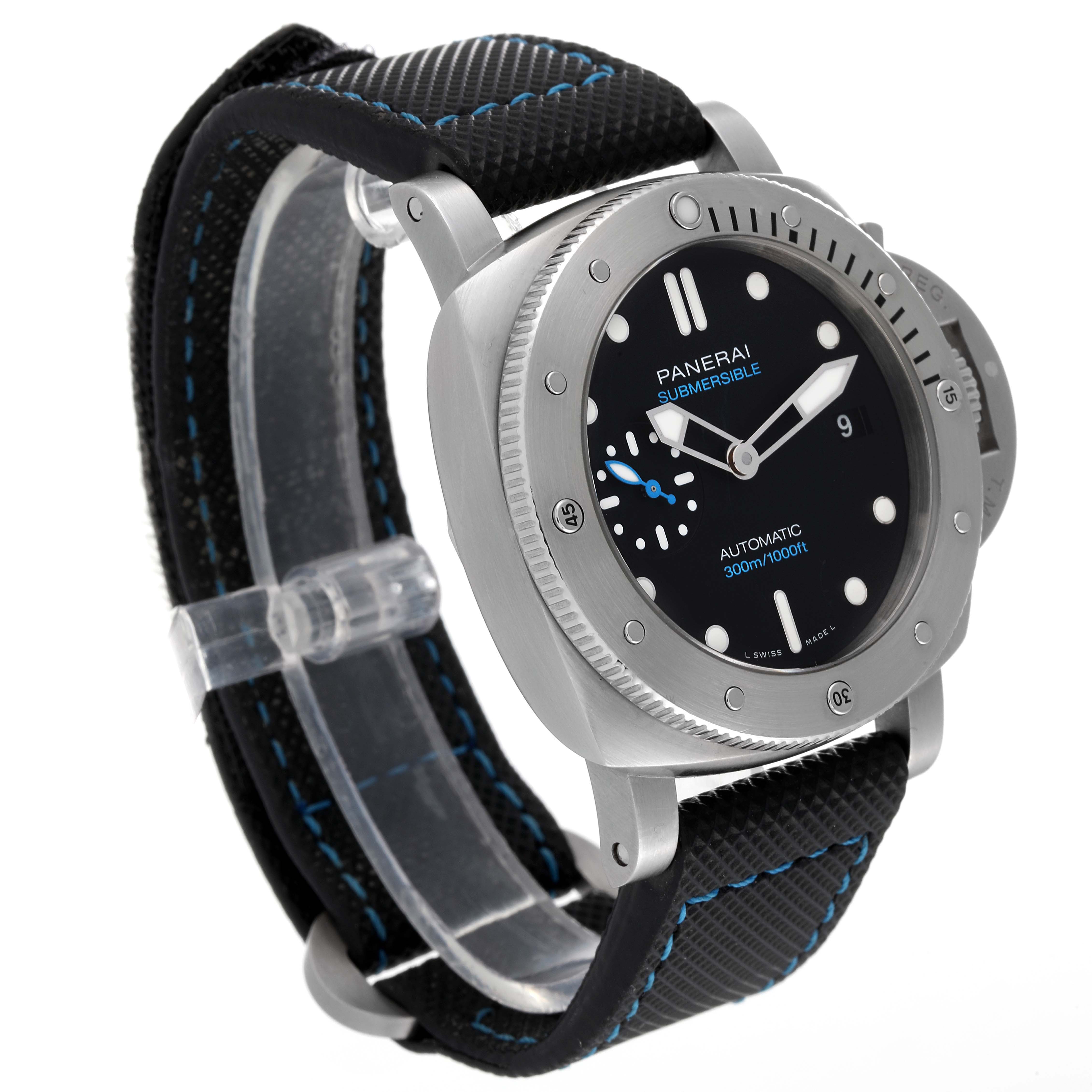 This image portrays a Panerai Submersible PAM00973 Men's Stainless Steel Black Dial PAM00973 Men's Stainless Steel Black Dial watch at a slight angle, displaying its face, bezel, and textured strap with blue stitching.