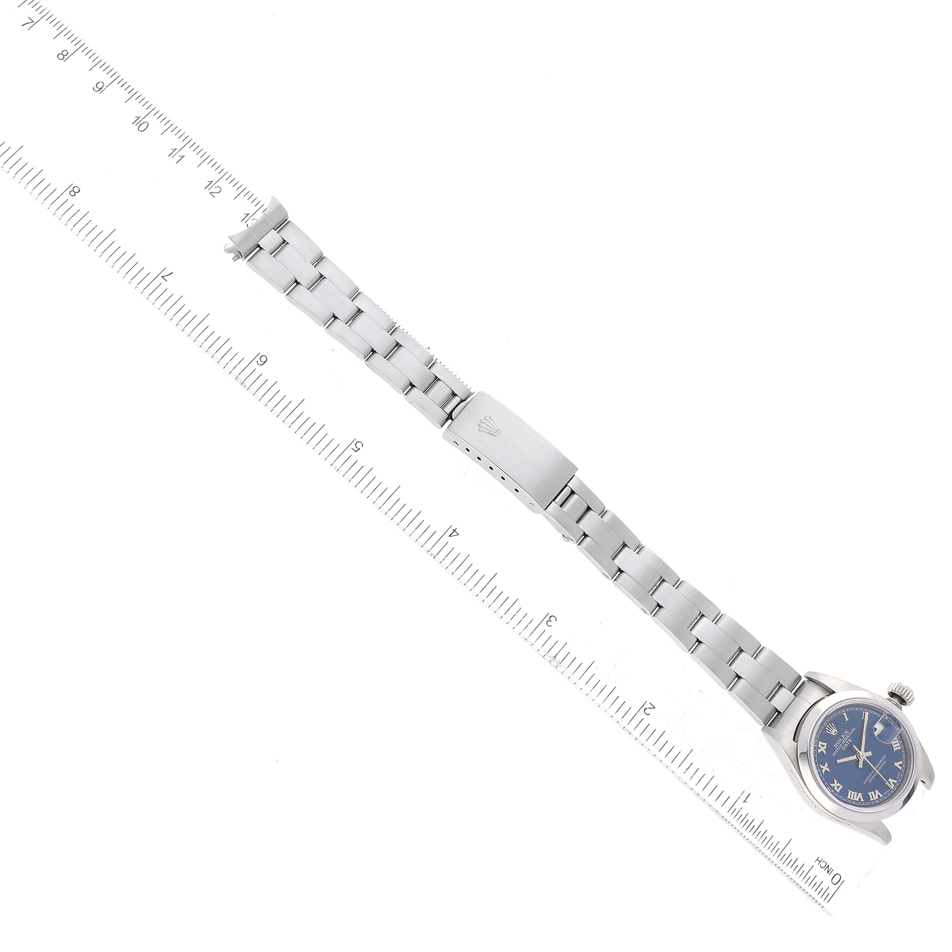 This image shows the Rolex Date 79160 Women's Stainless Steel Blue Dial 79160 Women's Stainless Steel Blue Dial model watch laid flat with rulers aligned along its side for measurement.