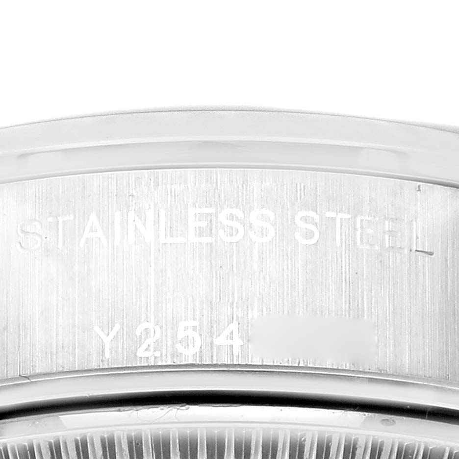 The image shows the inner bezel engraving of a Rolex Date 79160 Women's Stainless Steel Blue Dial 79160 Women's Stainless Steel Blue Dial watch, focusing on the stainless steel text and serial number.