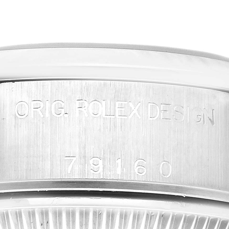 This image shows a close-up of the side engraving on the case of a Rolex Date 79160 Women's Stainless Steel Blue Dial 79160 Women's Stainless Steel Blue Dial model, displaying "ORIG. ROLEX DESIGN" and the model number.