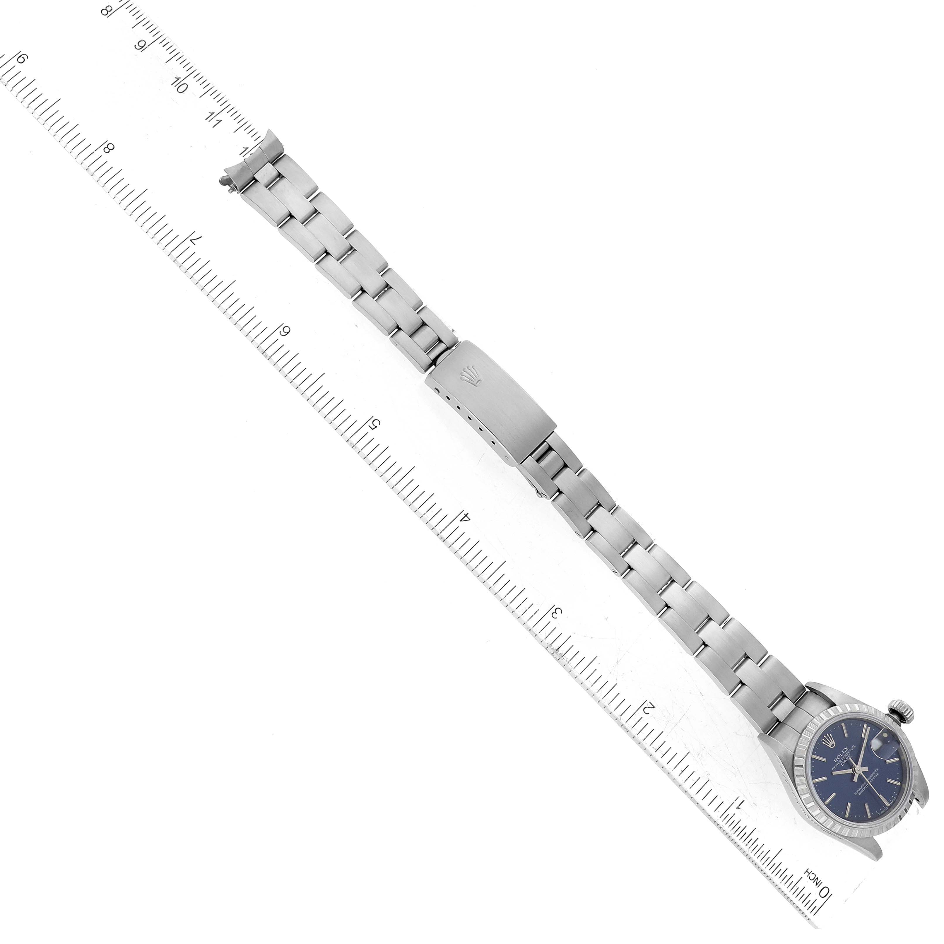 The watch, a Rolex Date 69240 Women
s Stainless Steel Blue Dial 69240 Women
s Stainless Steel Blue Dial model, is shown from the top angle with the face and full bracelet aligned alongside a ruler.