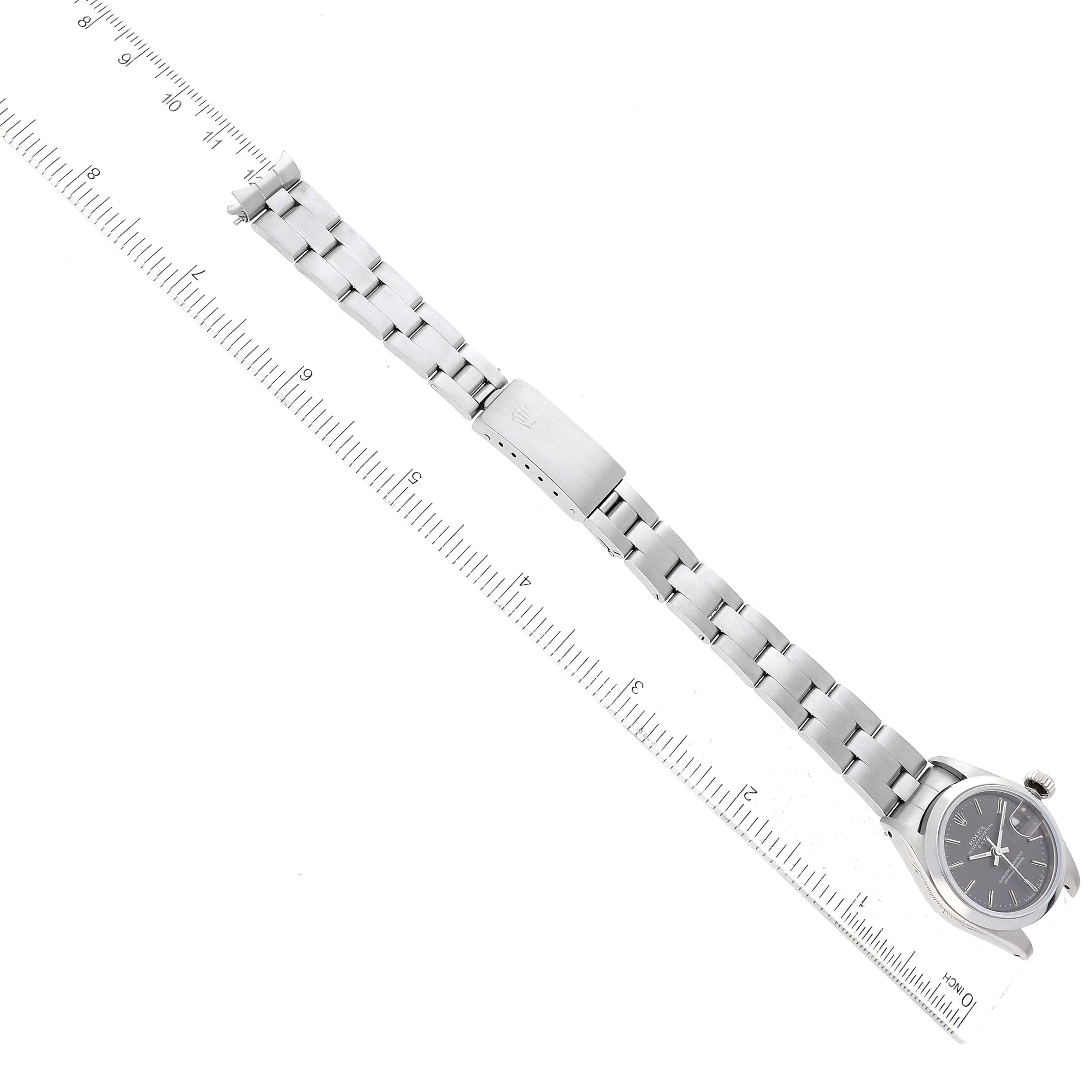 The image shows a Rolex Date 69160 Women
s Stainless Steel Grey Dial 69160 Women
s Stainless Steel Grey Dial watch laid flat with a ruler for size reference, highlighting the band and face from a top-down angle.