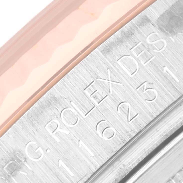 The image shows an angled close-up of the engraved bezel on a Rolex Datejust 116231 Men's Steel and Gold (two tone) Pink Dial 116231 Men's Steel and Gold (two tone) Pink Dial watch.