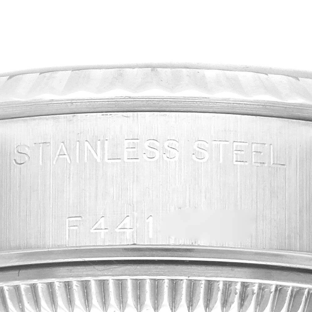 This close-up shows the side engraving and part of the fluted bezel on a Rolex Datejust 79174 Women's Stainless Steel Black Dial 79174 Women's Stainless Steel Black Dial watch.