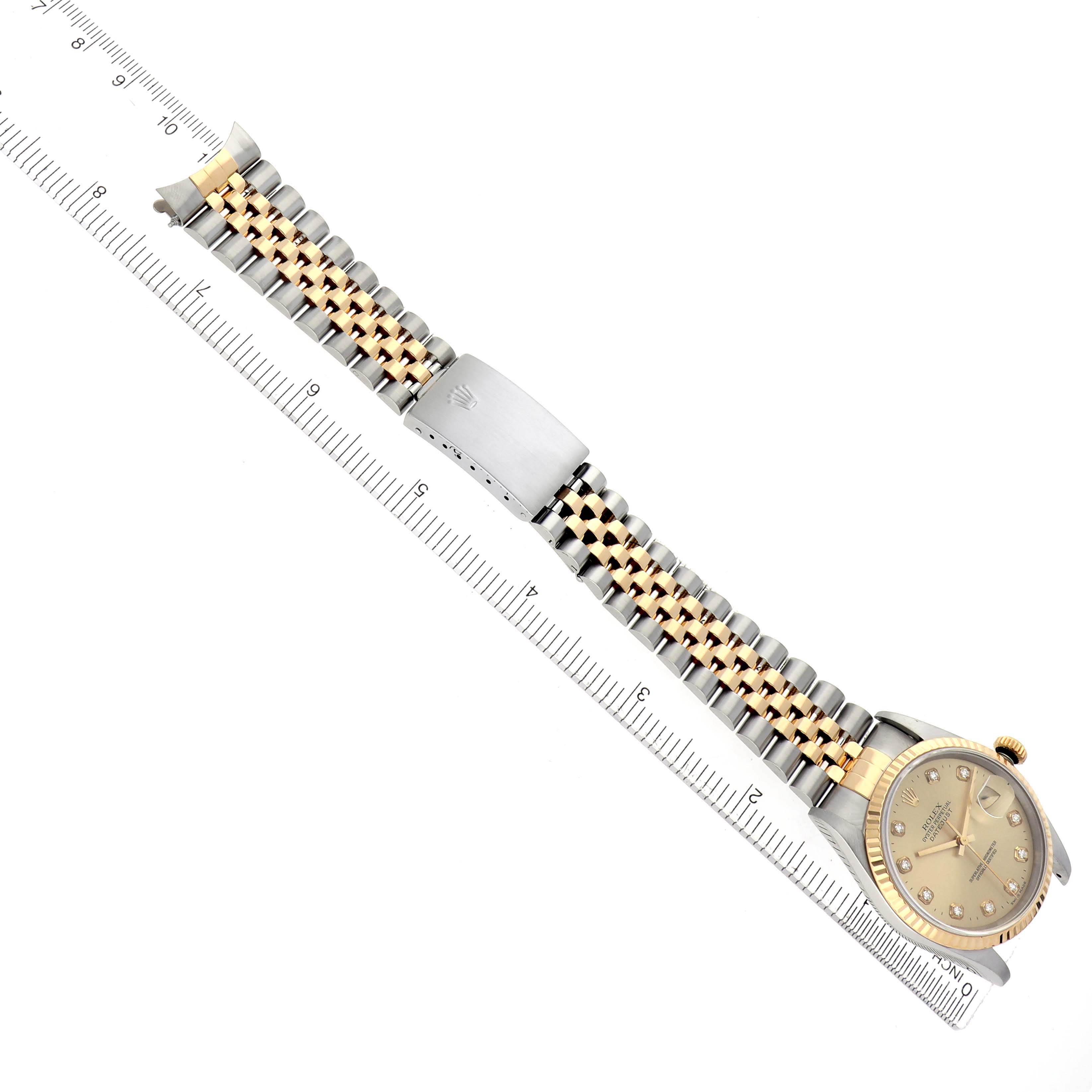 The image shows a Rolex Datejust model 16233 men's watch at an angled top view, featuring its two-tone bracelet, clasp, and dial with a ruler for scale.