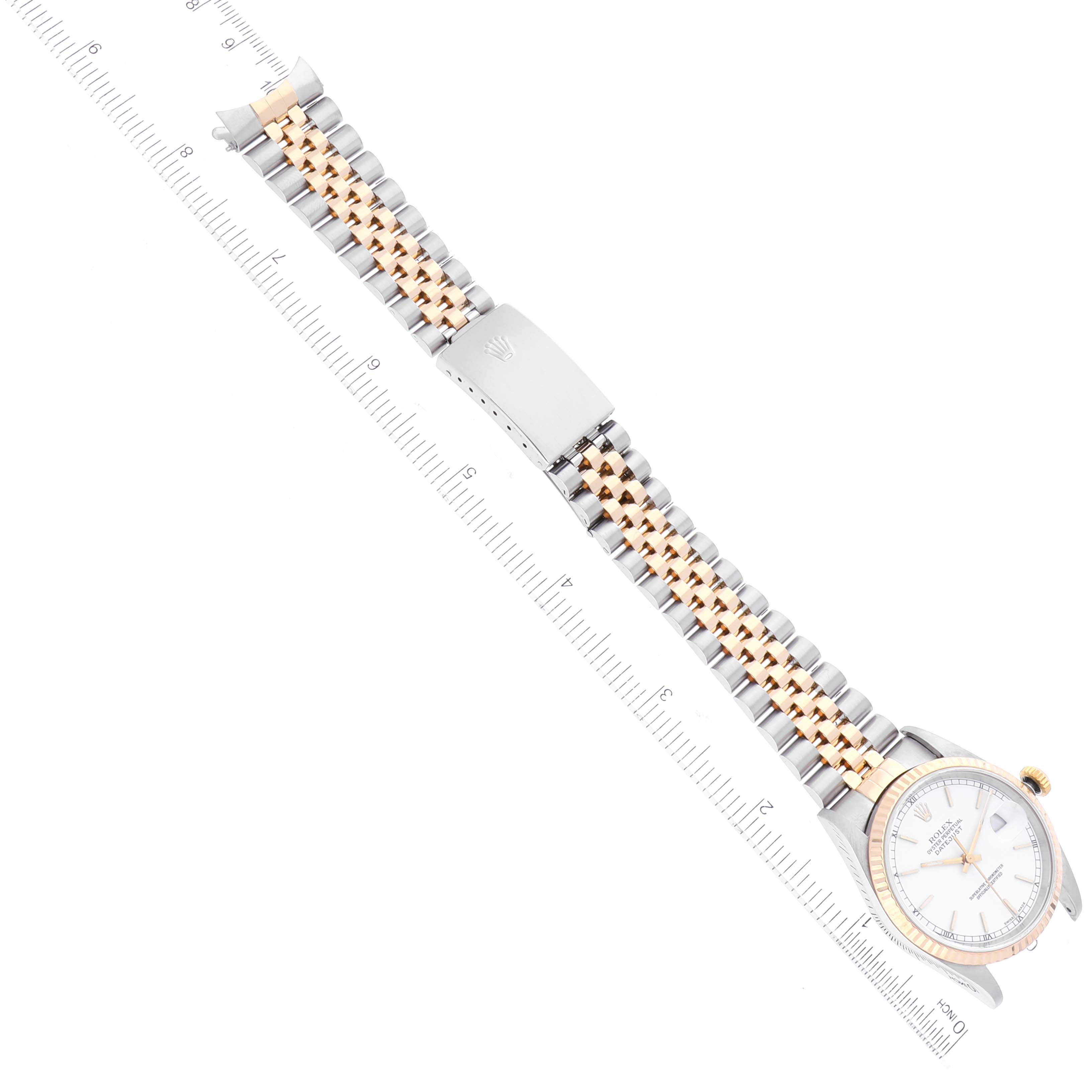 The image shows a top view of a Rolex Datejust 16233 Men's Steel and Gold (two tone) White Dial 16233 Men's Steel and Gold (two tone) White Dial watch with a two-tone bracelet and a measuring ruler for scale.