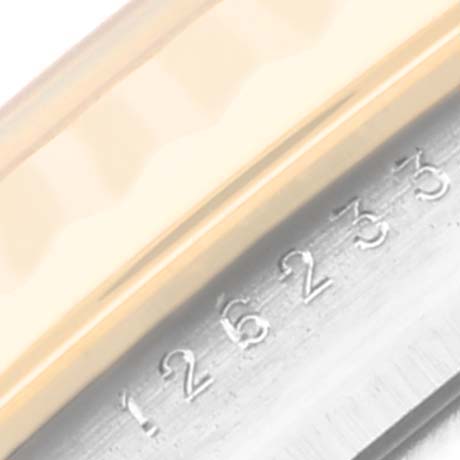 This close-up image of the Rolex Datejust 126233 Men
s Steel and Gold (two tone) Champagne Dial 126233 Men
s Steel and Gold (two tone) Champagne Dial watch shows part of the bezel and the serial number engraving on the case.