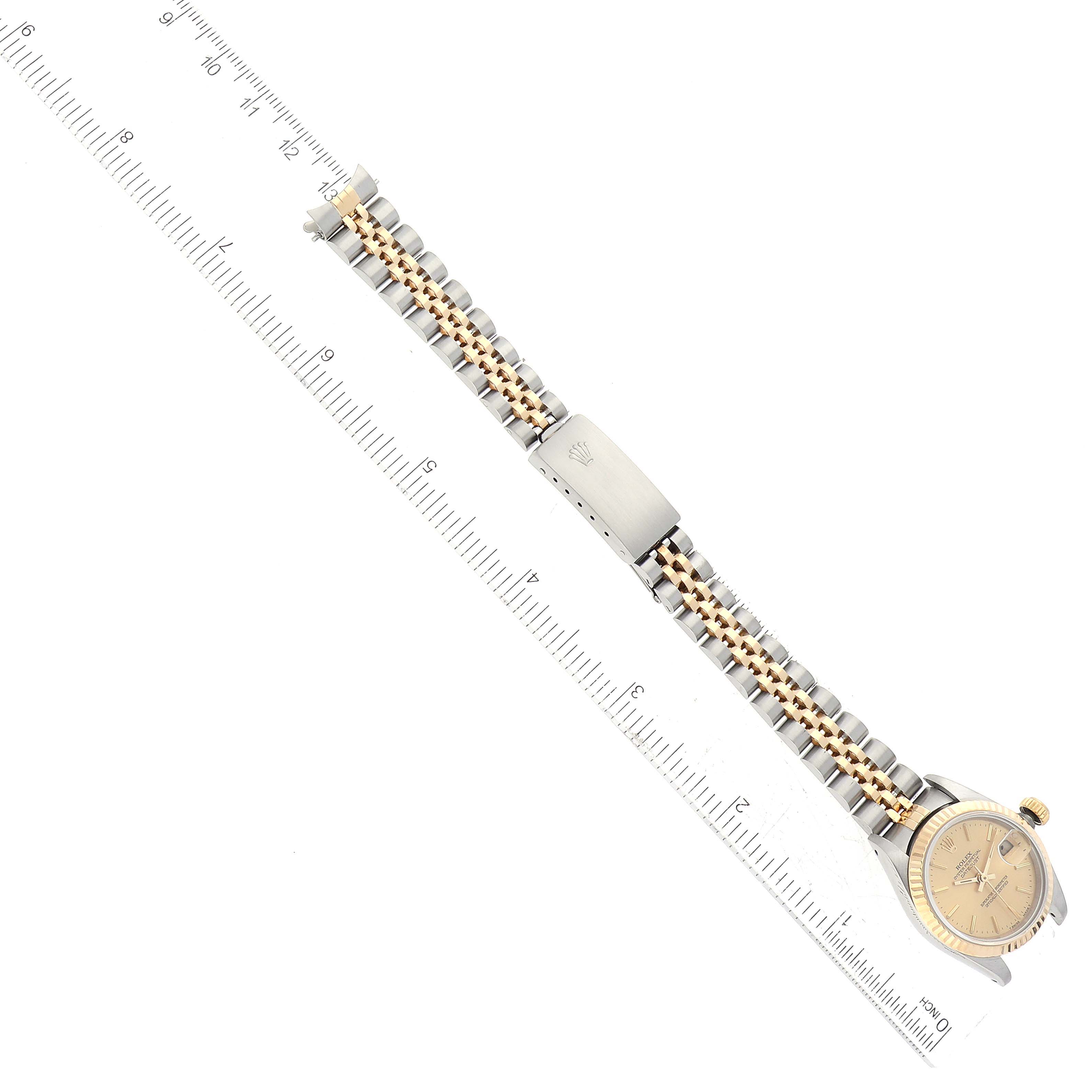 The image shows a Rolex Datejust 69173 Women's Steel and Gold (two tone) Champagne Dial 69173 Women's Steel and Gold (two tone) Champagne Dial watch laid flat with the full band and clasp visible, next to a ruler for scale.