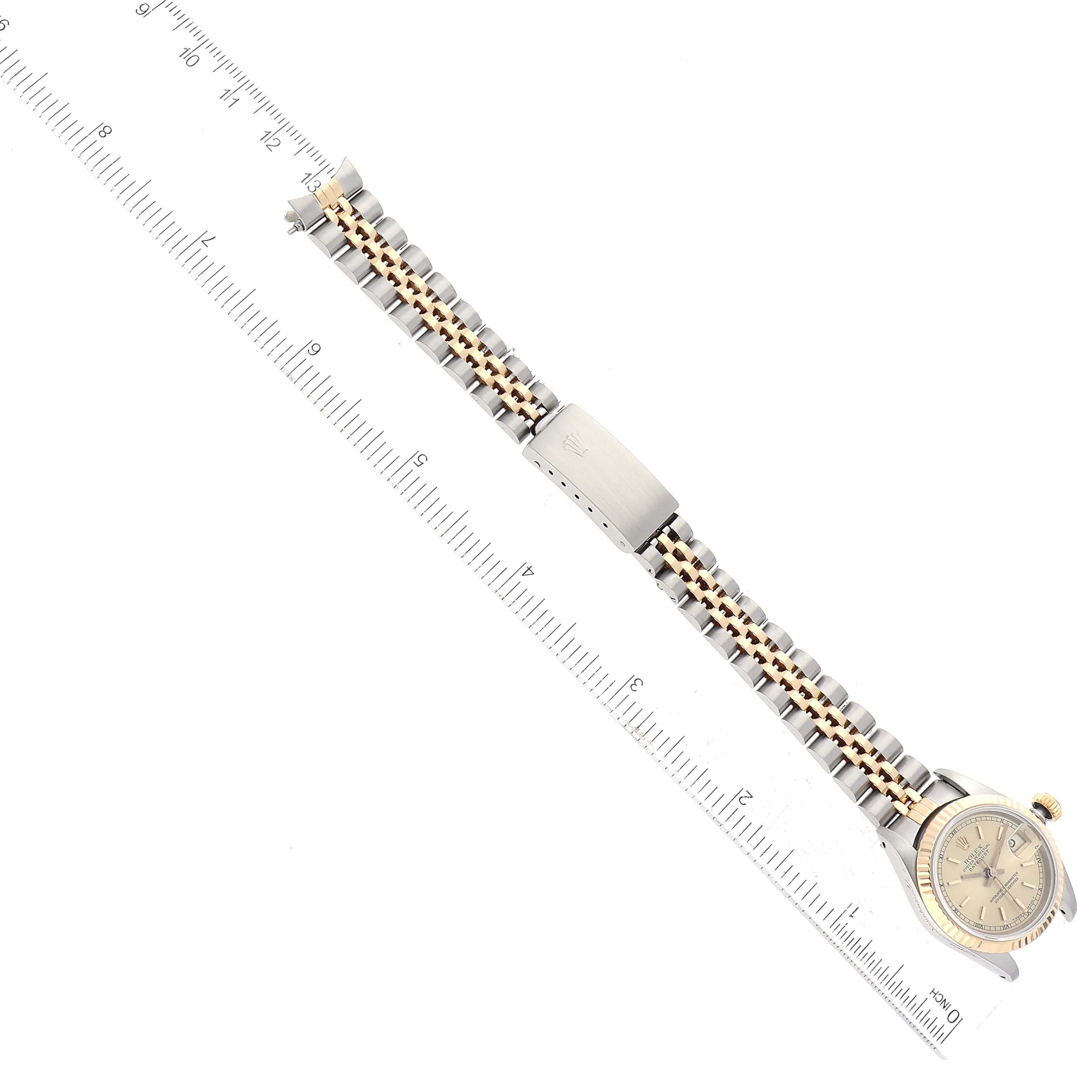 The image shows a top-down view of a Rolex Datejust 69173 Women's Steel and Gold (two tone) Champagne Dial 69173 Women's Steel and Gold (two tone) Champagne Dial model watch with its full bracelet extended and placed alongside a ruler for scale.
