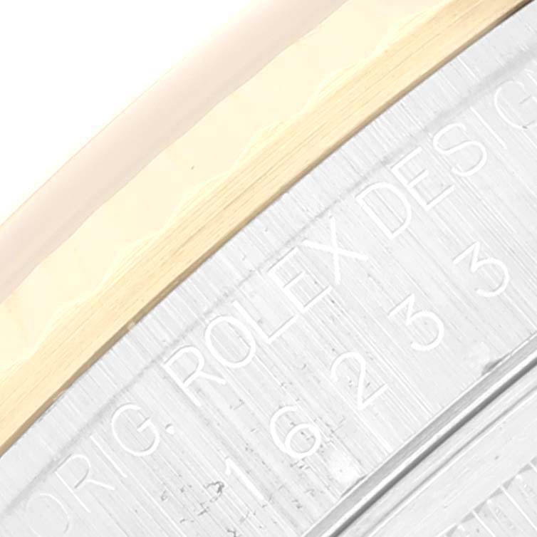 This close-up image of the Rolex Datejust 16233 Men's Steel and Gold (two tone) White Dial 16233 Men's Steel and Gold (two tone) White Dial watch shows part of the bezel and case engraved with the model number.