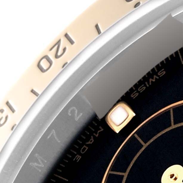 The image shows a close-up of the bezel, part of the dial, and an hour marker of a Rolex Daytona 116523 Men's Steel and Gold (two tone) Black Dial 116523 Men's Steel and Gold (two tone) Black Dial watch.