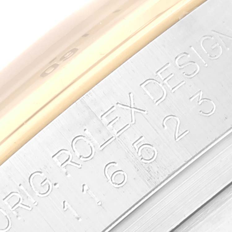 This image shows a close-up view of the engraved serial number and "ORIG. ROLEX DESIGN" on the side of a Rolex Daytona 116523 Men's Steel and Gold (two tone) Black Dial 116523 Men's Steel and Gold (two tone) Black Dial watch case.